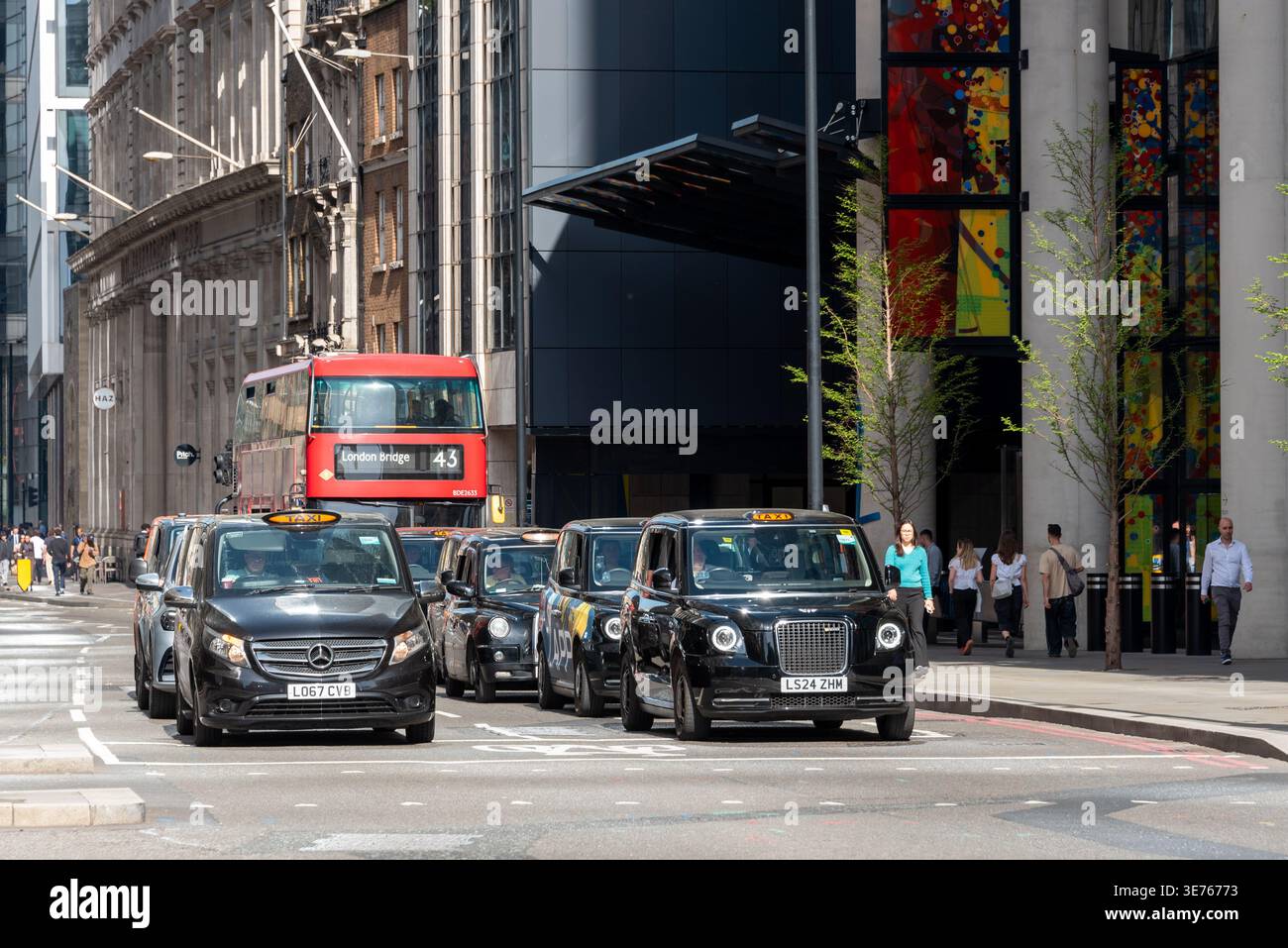 London's iconic black cabs are waiting at traffic lights in central London, UK Stock Photo