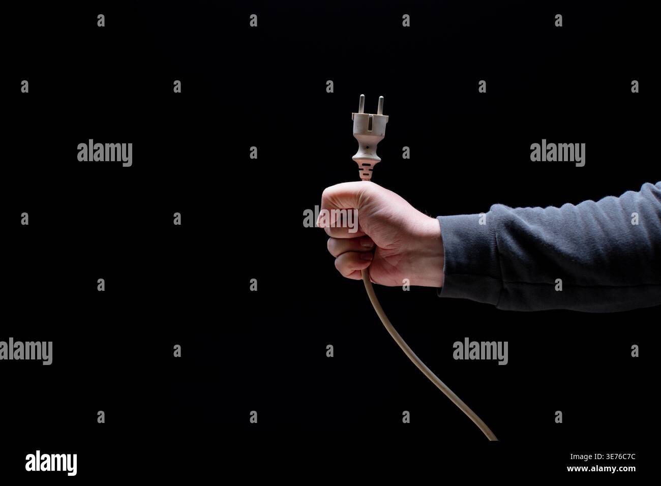 Hand holding cable with power connector Stock Photo