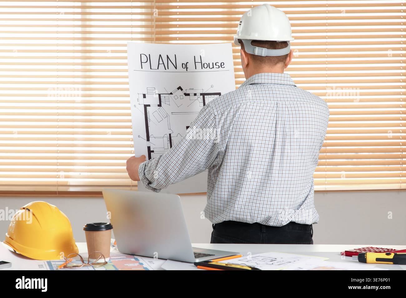 Male constructor working with house plan in office, back view Stock Photo