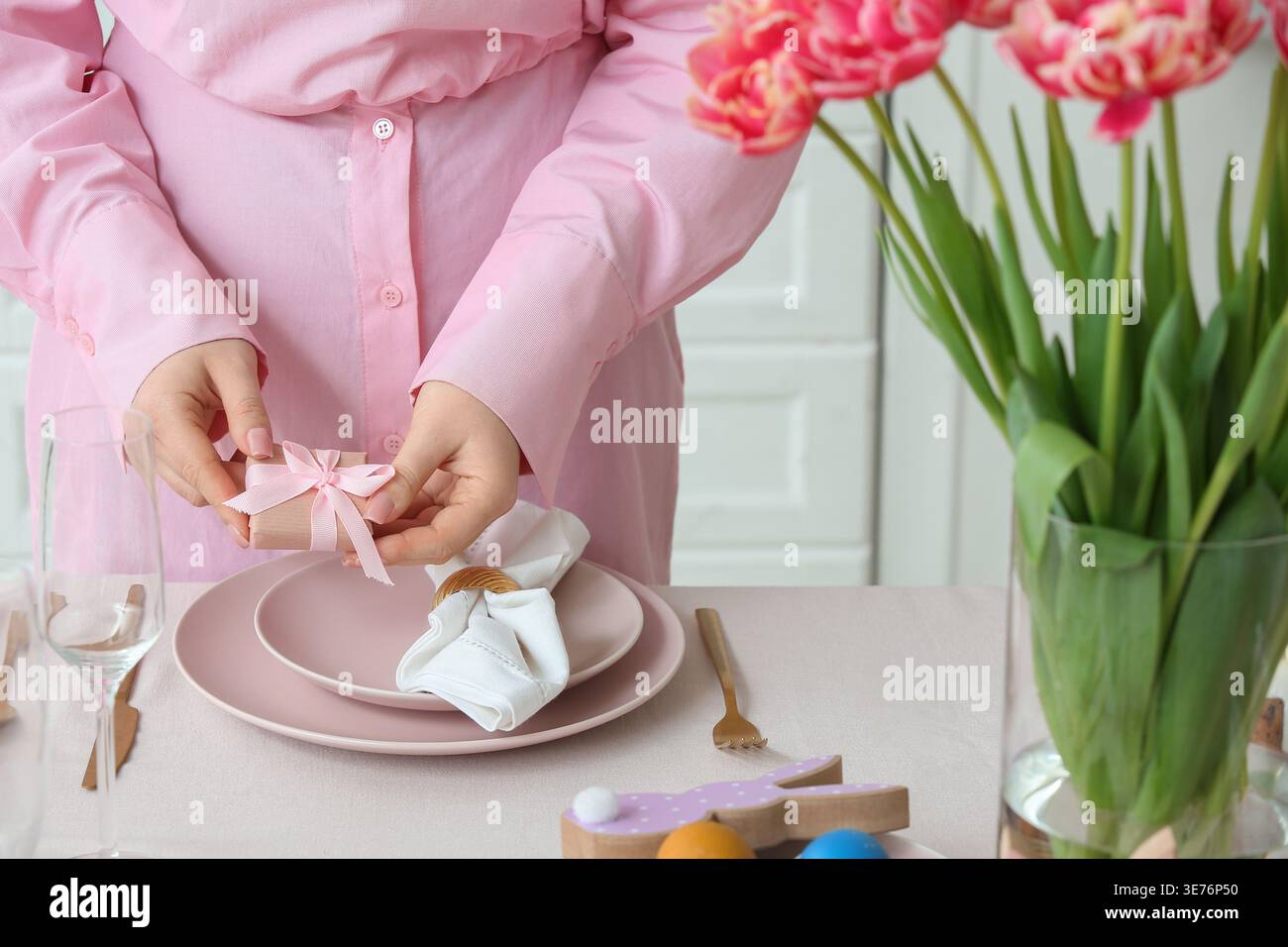 Woman serving dining table for Easter celebration. Closeup Stock Photo