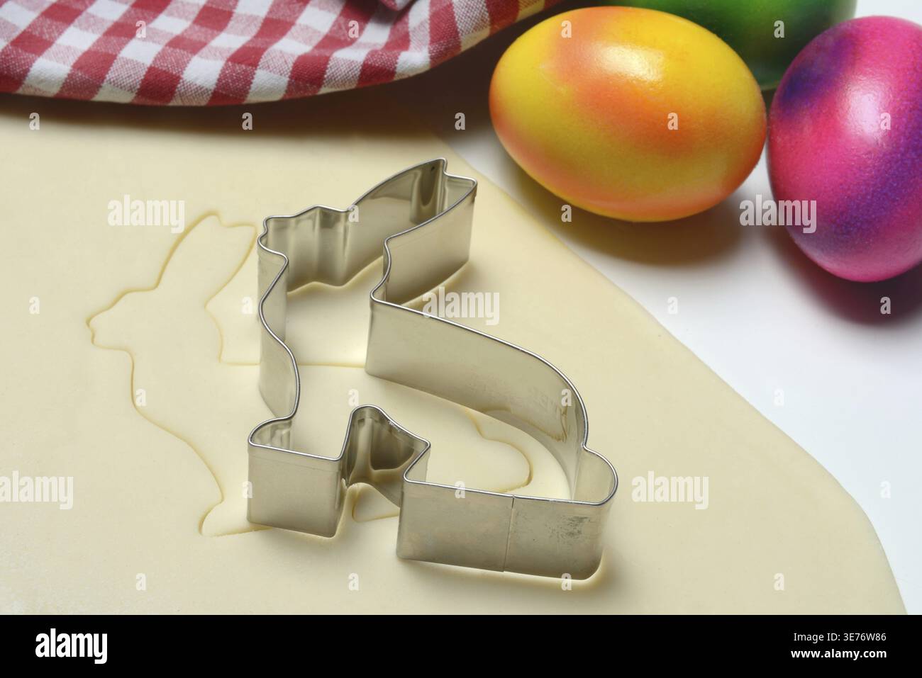 Rolled dough with bunny cookie cutter and easter eggs Stock Photo