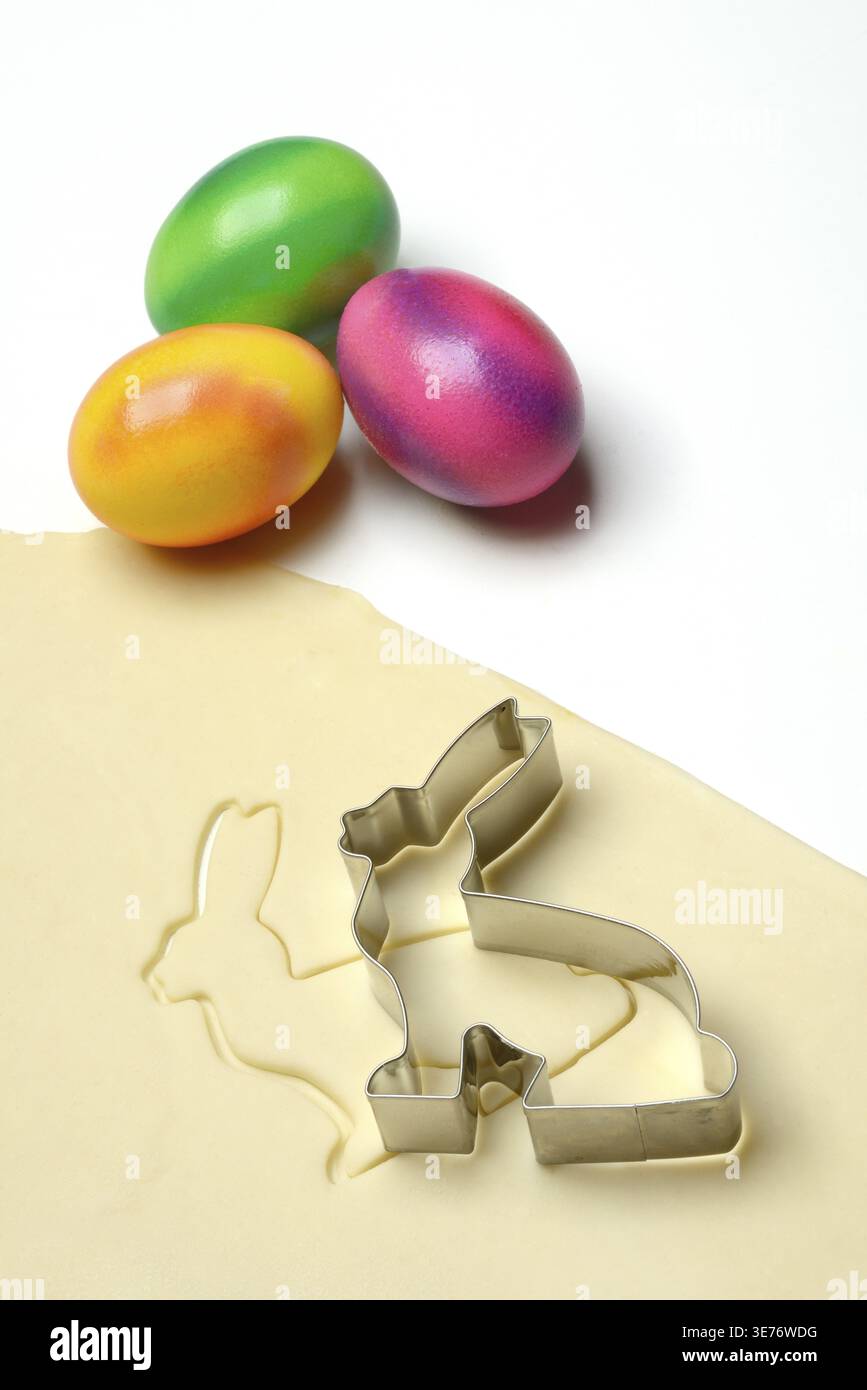 Rolled dough with bunny cookie cutter and easter eggs Stock Photo