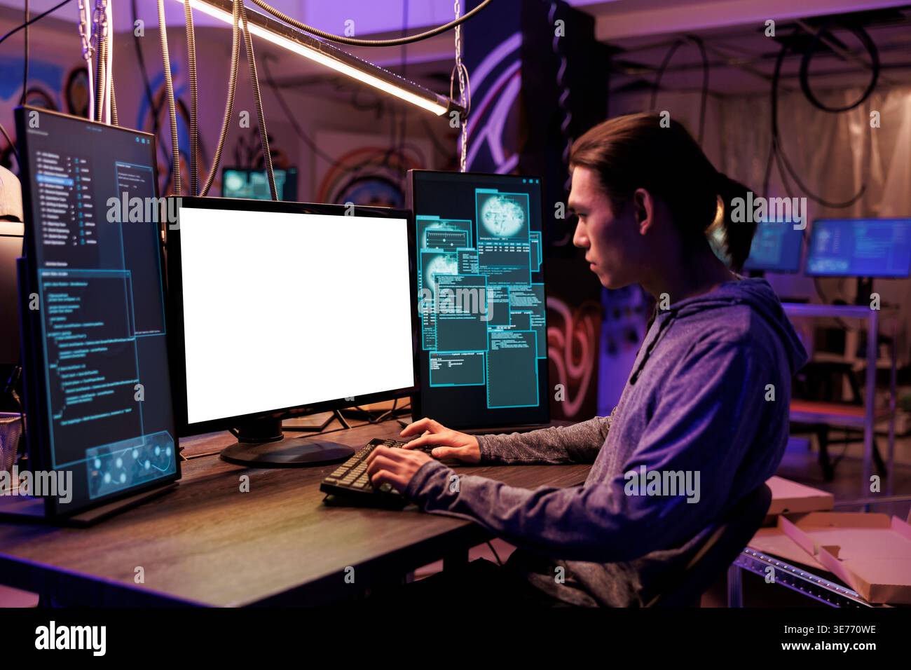 Asian hacker using computer with empty white screen for criminal activity. Criminal programming illegal malicious software and checking code on blank monitor mockup at night Stock Photo