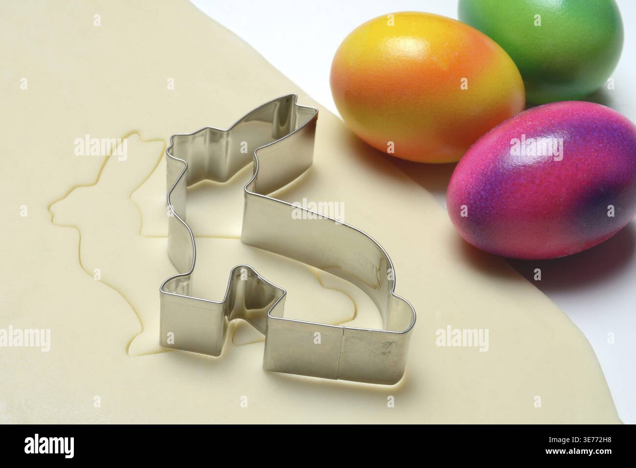 Rolled dough with bunny cookie cutter and easter eggs Stock Photo