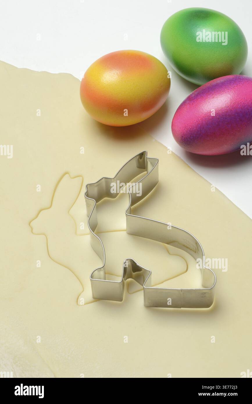 Rolled dough with bunny cookie cutter and easter eggs Stock Photo