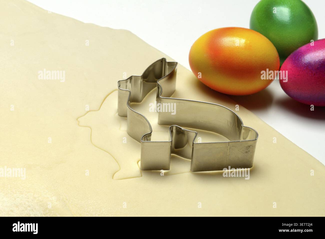 Rolled dough with bunny cookie cutter and easter eggs Stock Photo