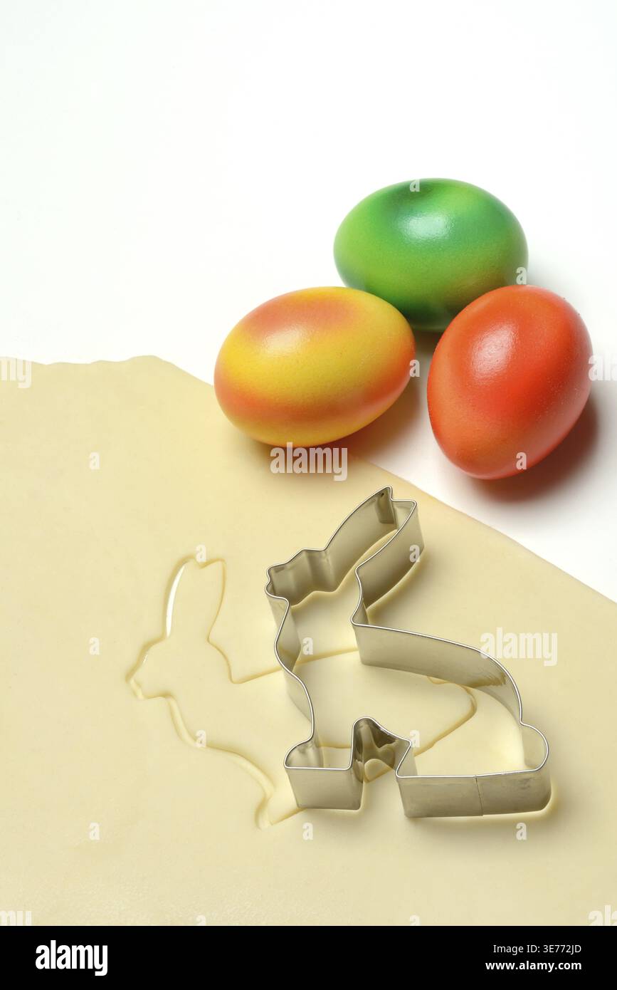 Rolled dough with bunny cookie cutter and easter eggs Stock Photo