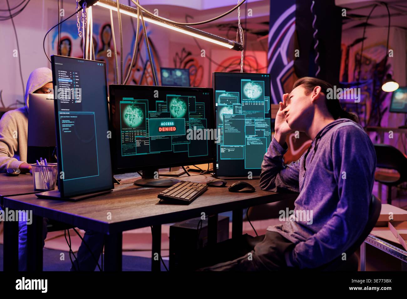 Unhappy hacker failing to pass server security system illegally. Young asian criminal getting access denied message on computer while hacking database server unsuccessfully Stock Photo