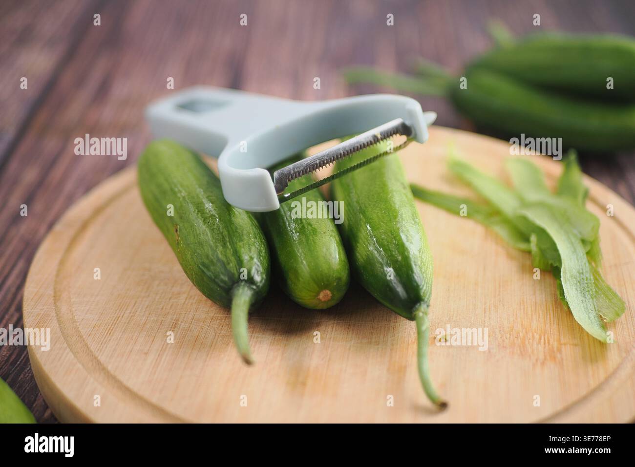 Cutting cucumbers on a wooden board Stock Photo