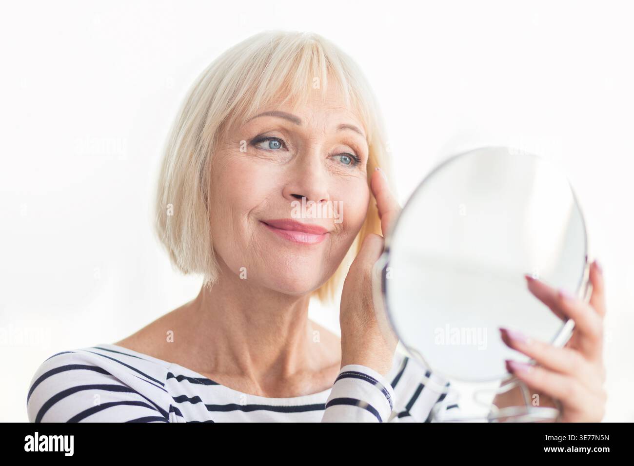 Senior woman touching her soft face skin Stock Photo