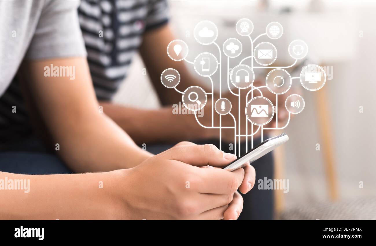 Young man using smartphone with virtual icons Stock Photo