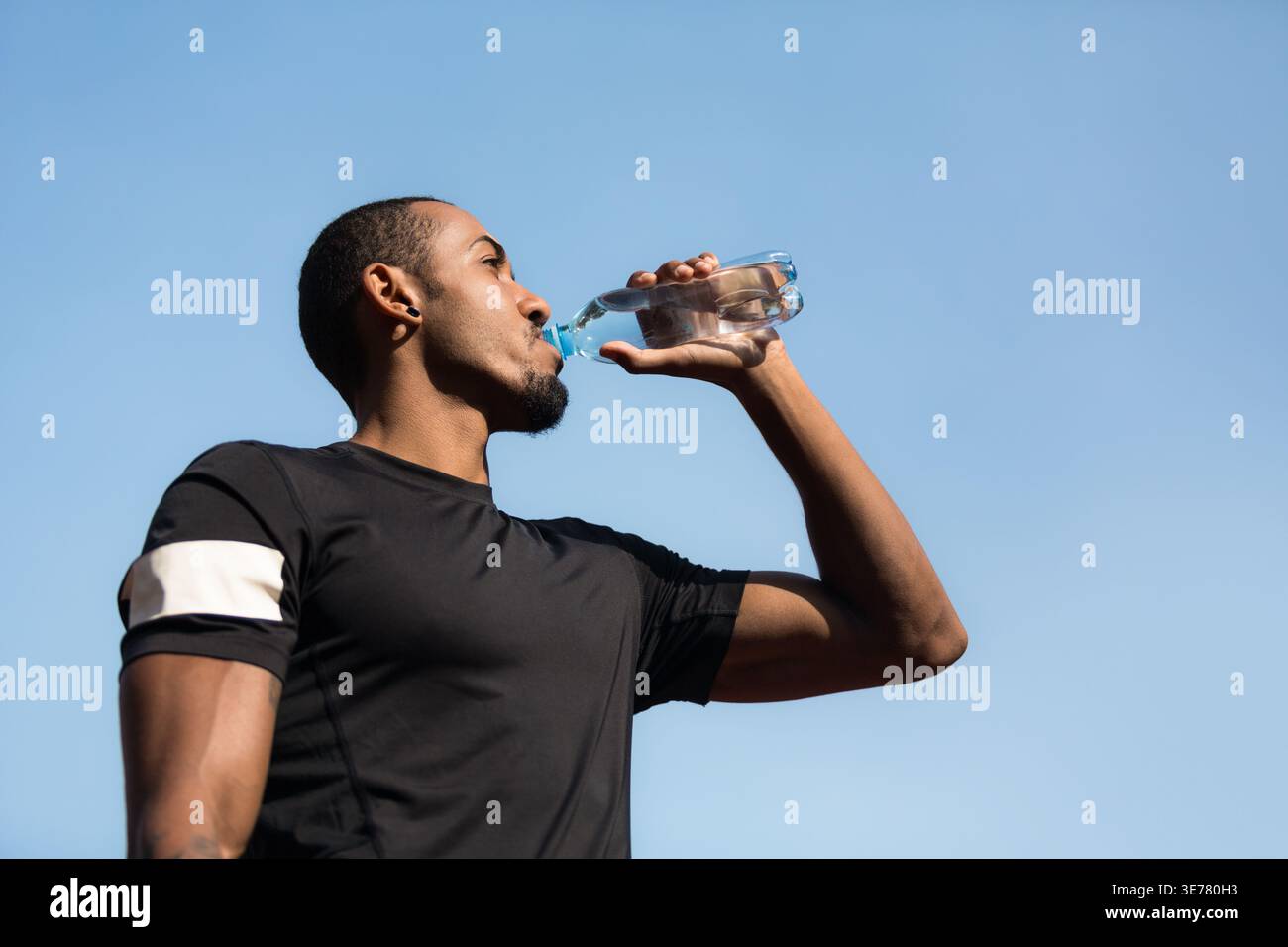 Man resting and drinking water after running Stock Photo