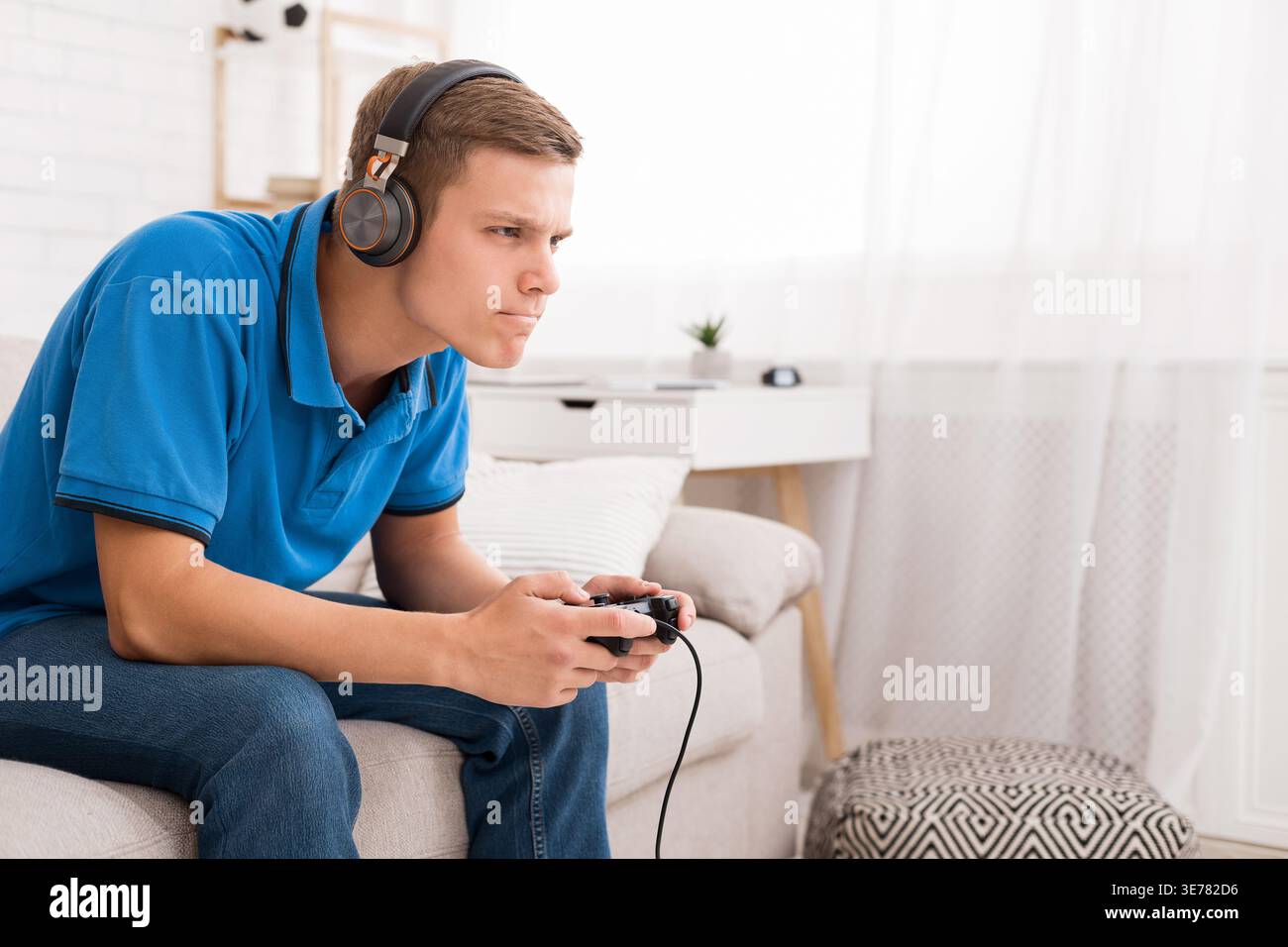 Concentrated guy playing video game with joystick Stock Photo