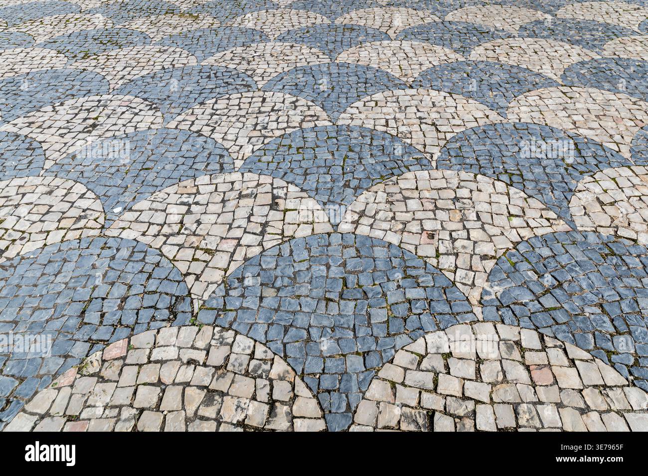 Portuguese cobblestone pavement with wave mosaic pattern Stock Photo