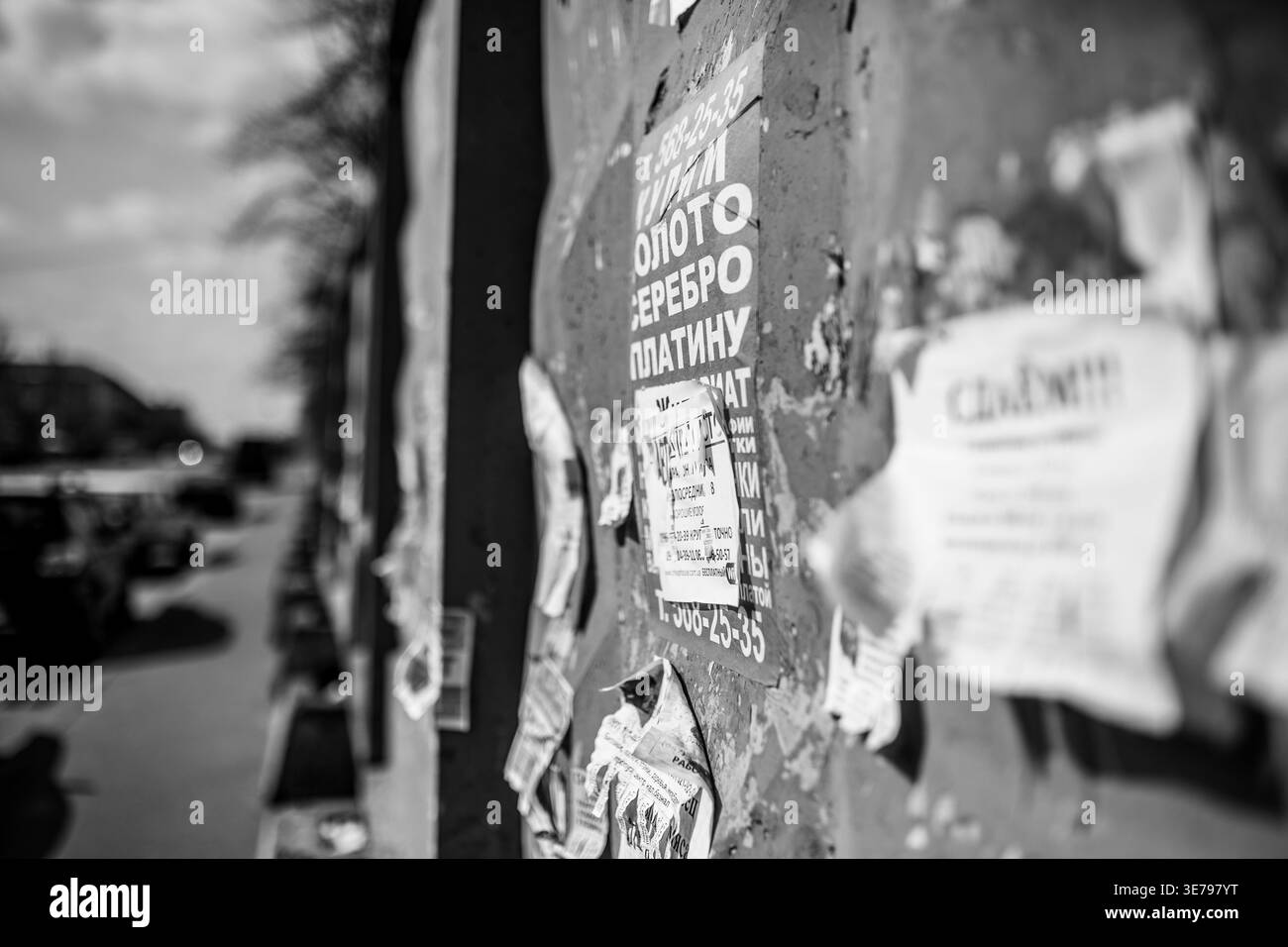 Darnytsia, Kyiv, Ukraine – Mar 21, 2014: Close-up monochrome view of a textured urban wall adorned with numerous layers of old, tattered, and peeling Stock Photo