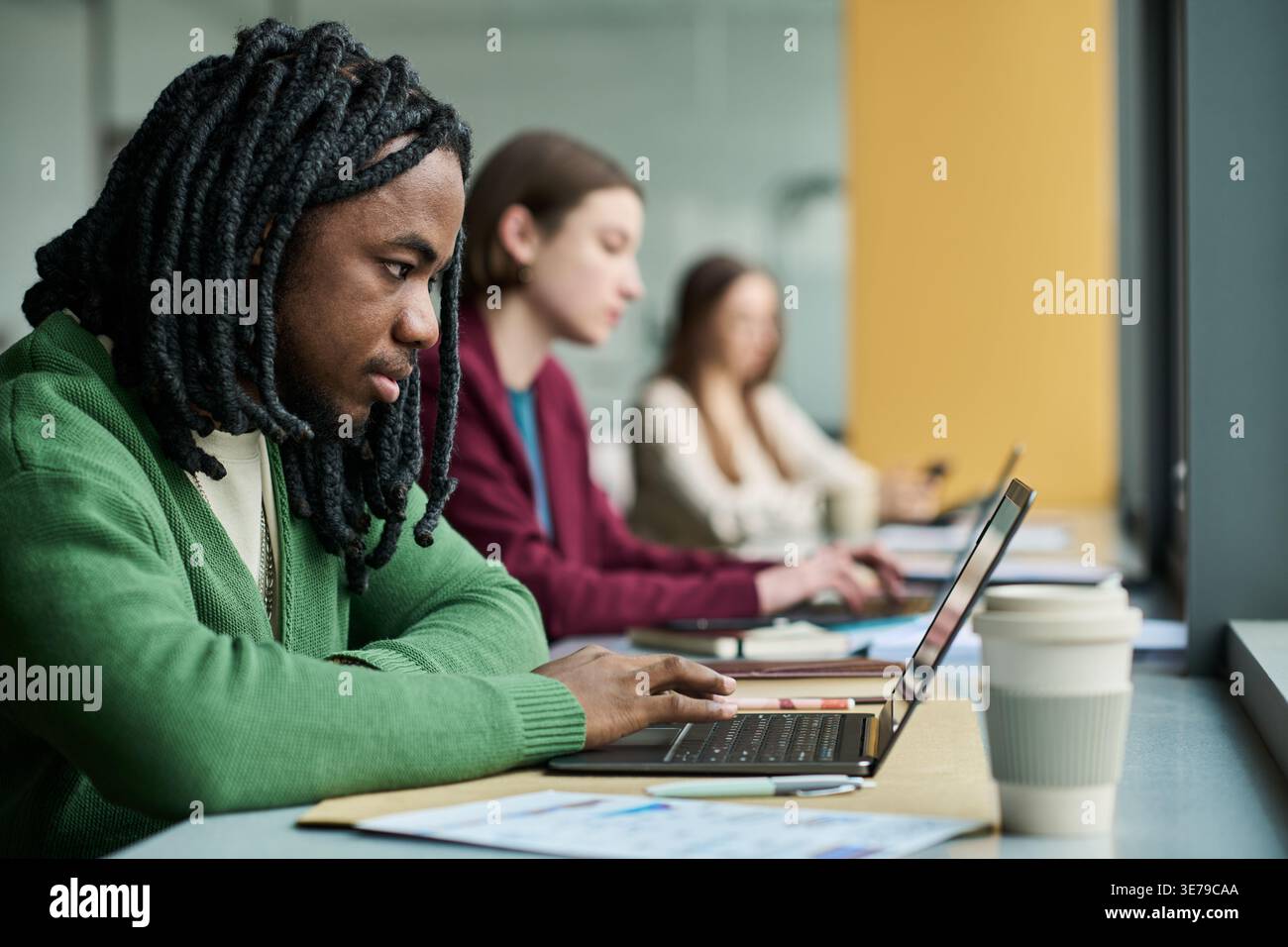 Black Man Typing on Laptop during Focused Office Work Session Stock Photo
