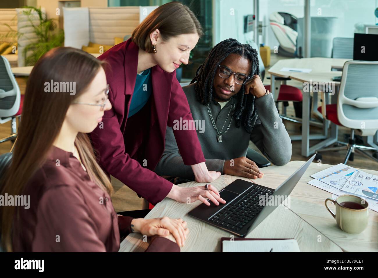 Diverse Coworkers Analyzing Laptop Data for Office Planning Stock Photo