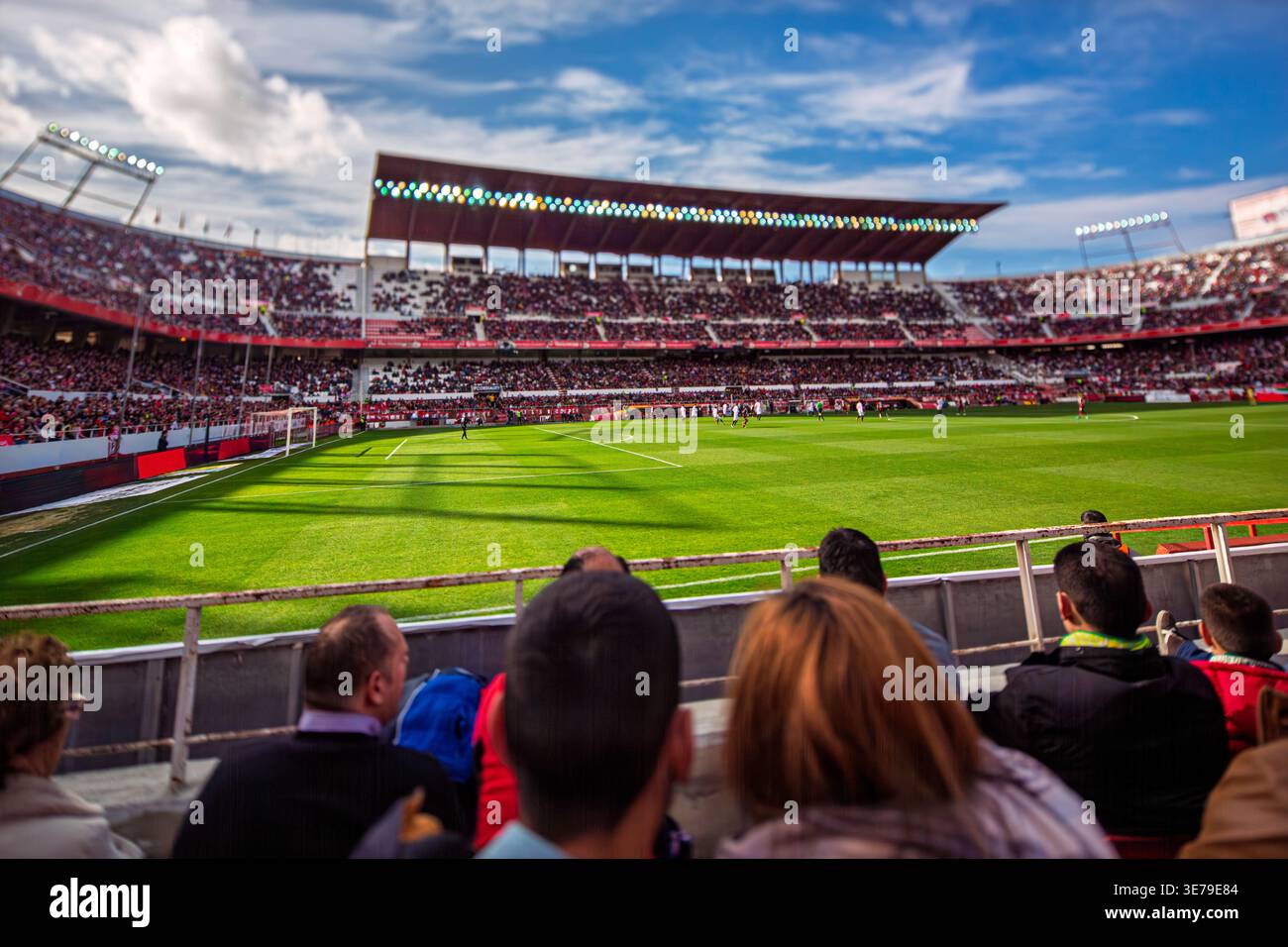 Spectators enjoy a professional football match in a Spanish stadium, captured with a distinctive tilt-shift effect that miniaturizes the vibrant scene Stock Photo