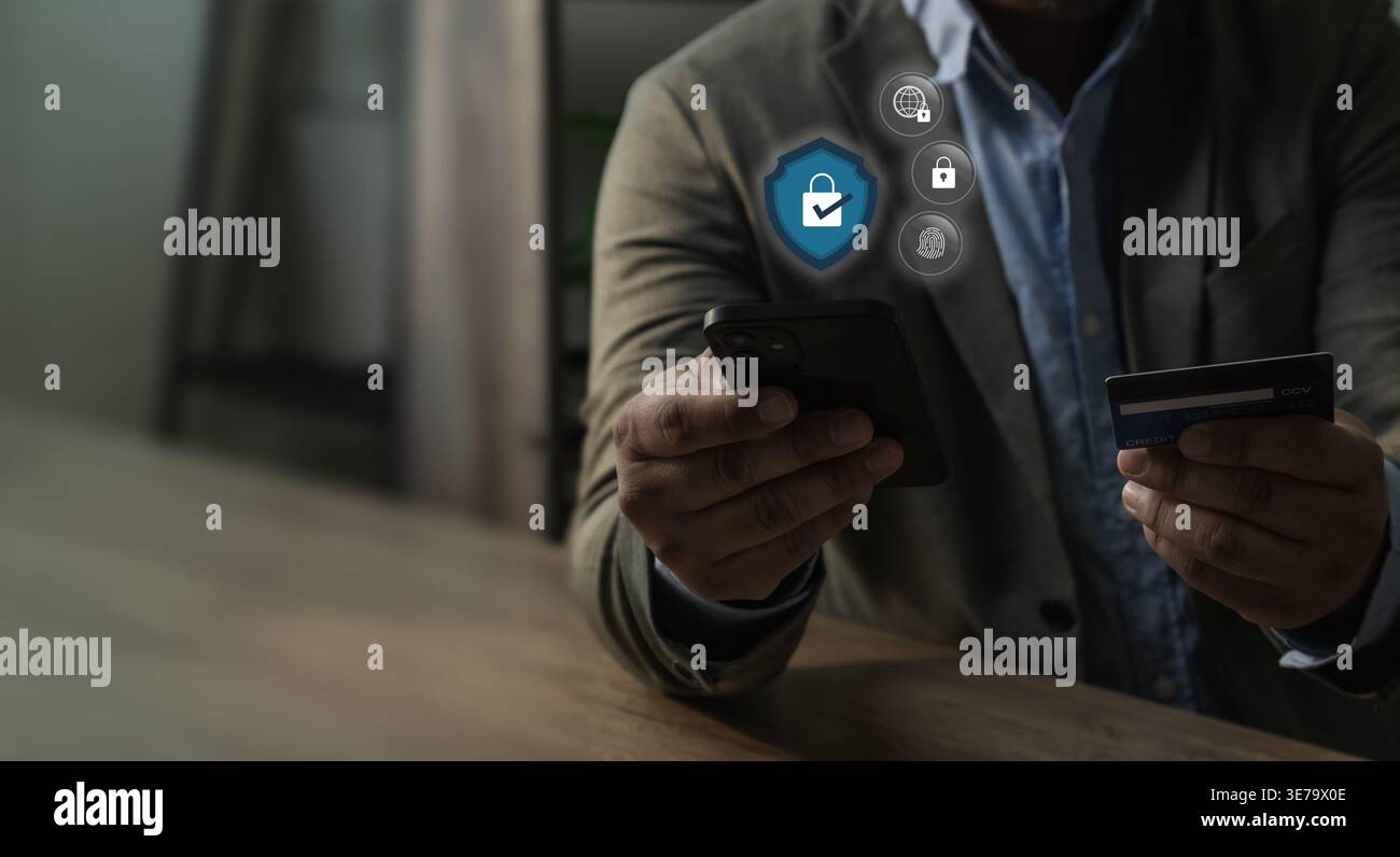 Hand holding smartphone and credit card performing mobile payment process with digital security icons showing authentication, verification, transactio Stock Photo