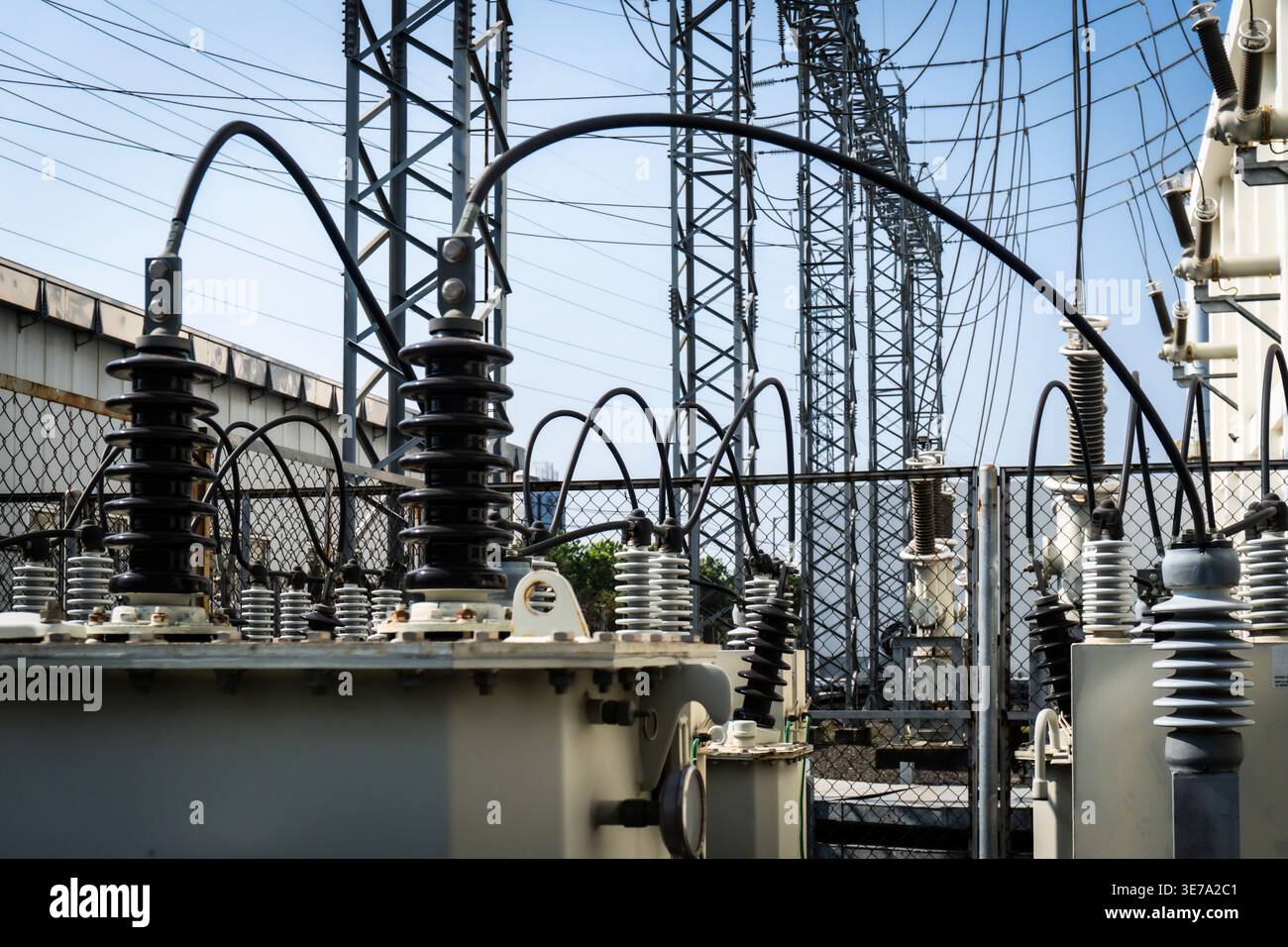 Large electrical substation with high-voltage equipment under bright ...