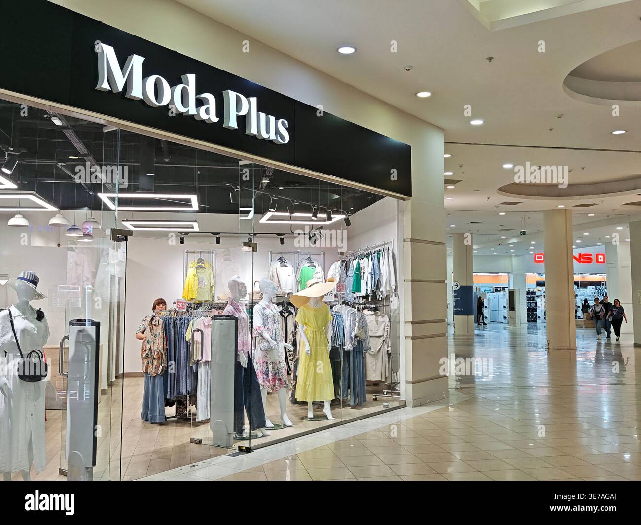 Kazan, Russia - June 13, 2025: Shoppers walk by the Moda Plus store ...