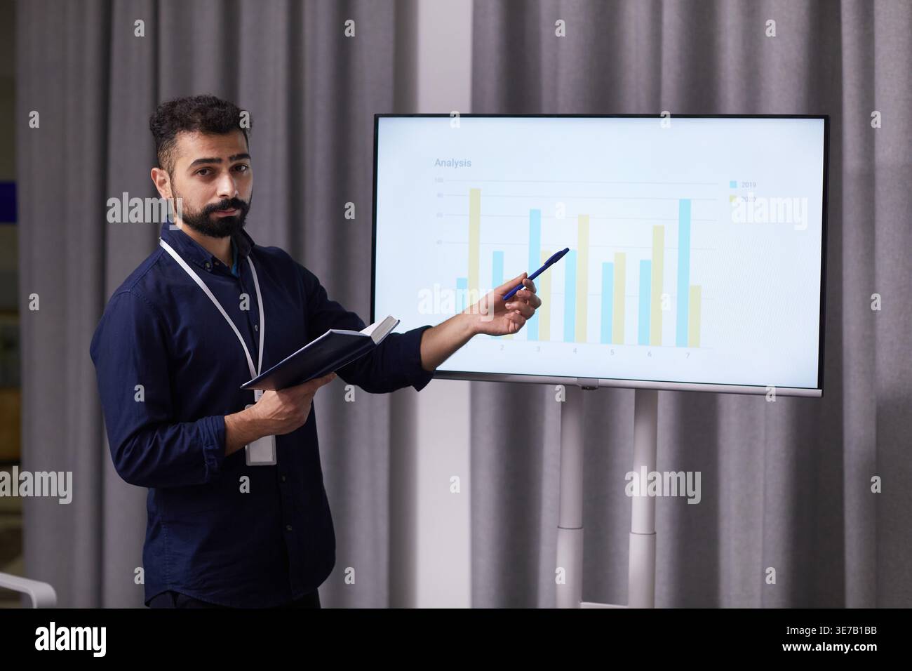 Mixed race doctor explaining graph standing in boardroom Stock Photo