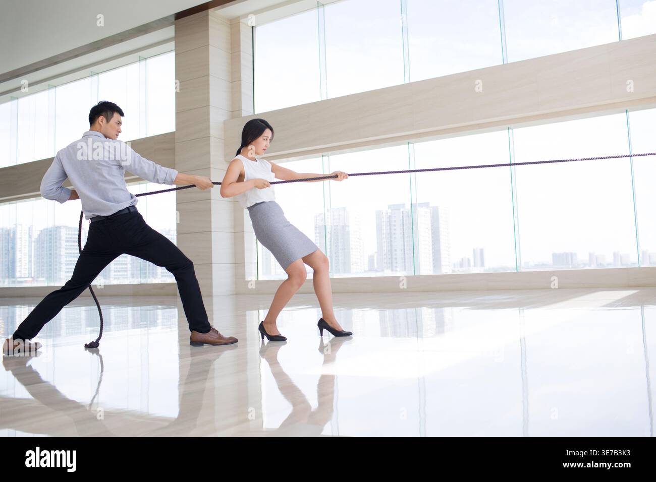 Worker Puling Rope Chinese male and female office workers pulling rope in recreation room ...