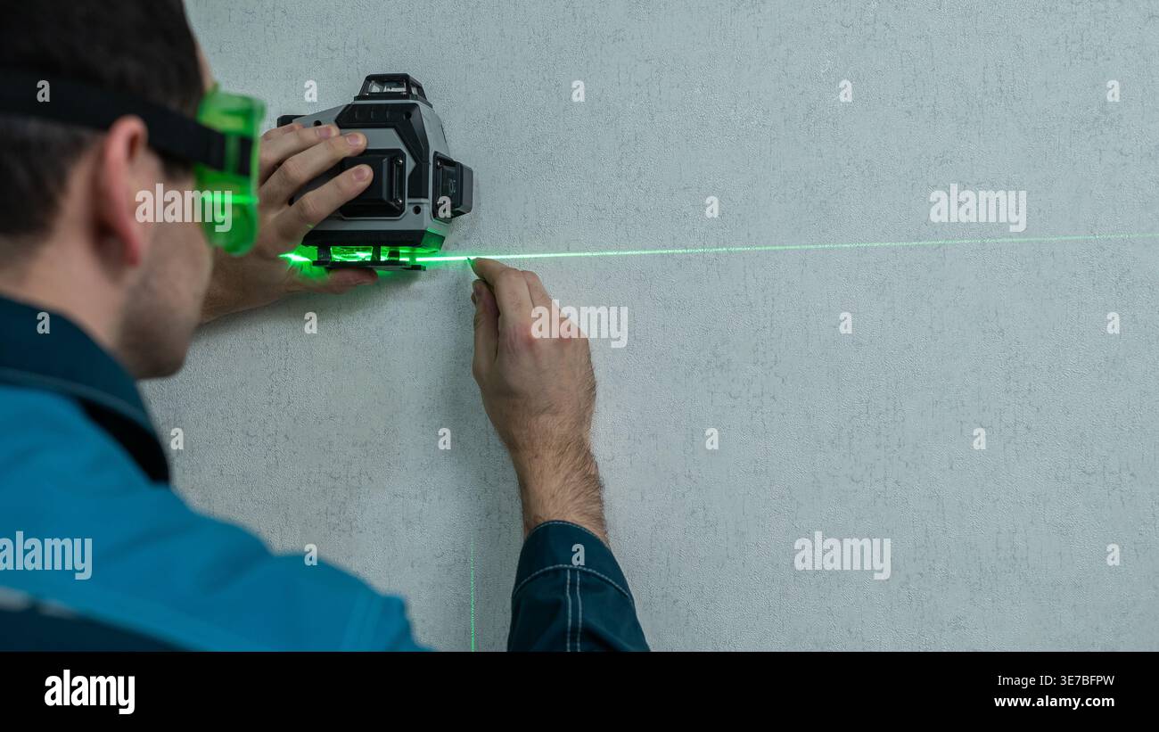 A man measures distance with a laser level.  Stock Photo