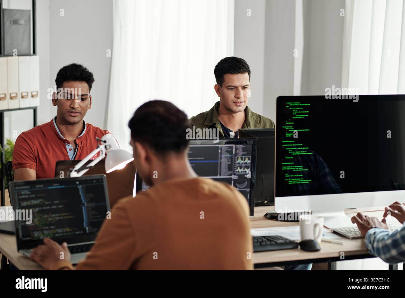 Indian male web developers writing codes for new computer program in IT office Stock Photo