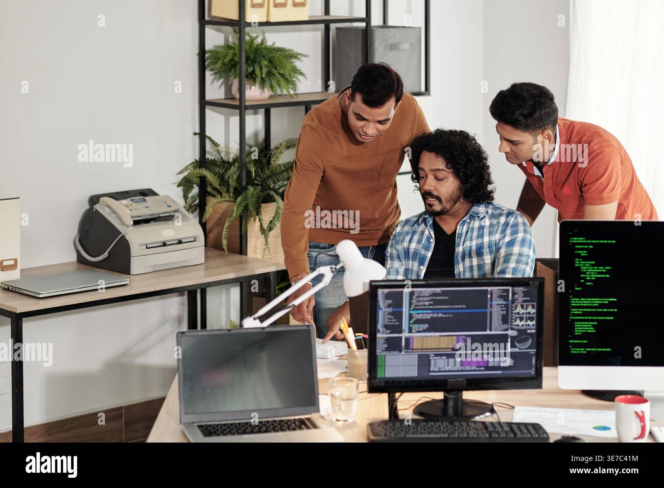 Indian male web developers writing codes for new computer program in IT office Stock Photo