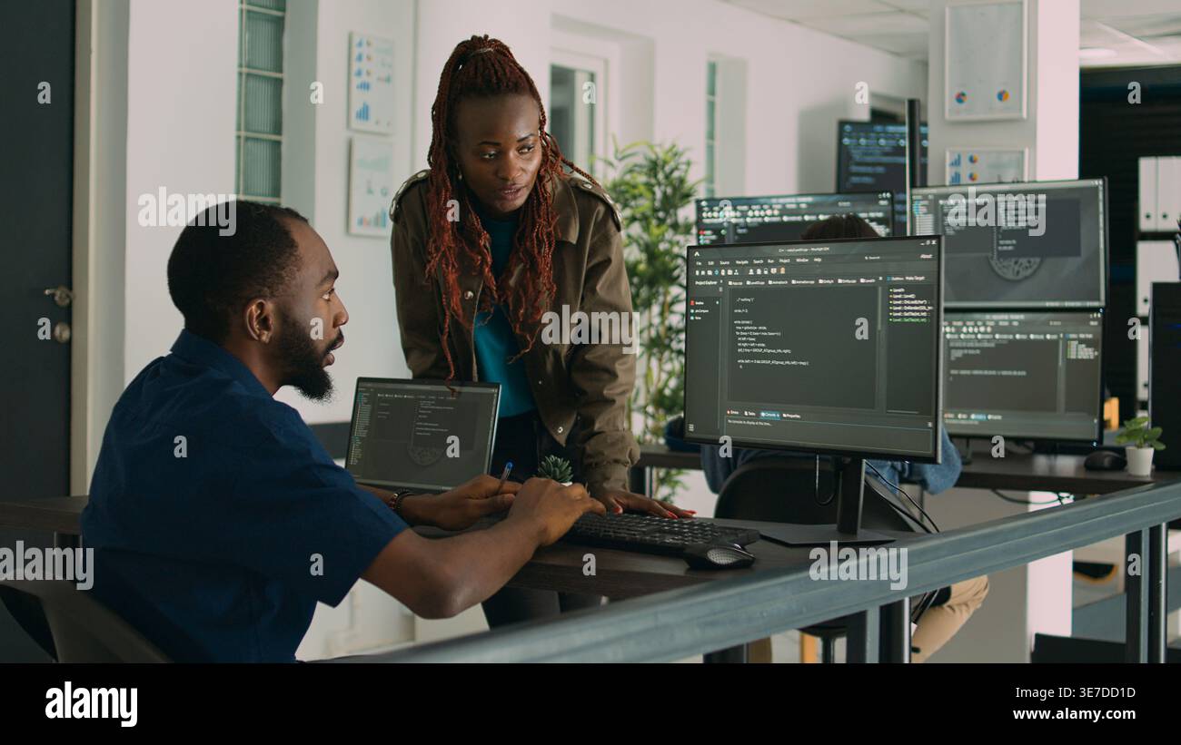 Software engineers brainstorming ideas to develop it code on computer, working on new user interface in agency office. Team of programmers collaborating on app development group project. Stock Photo