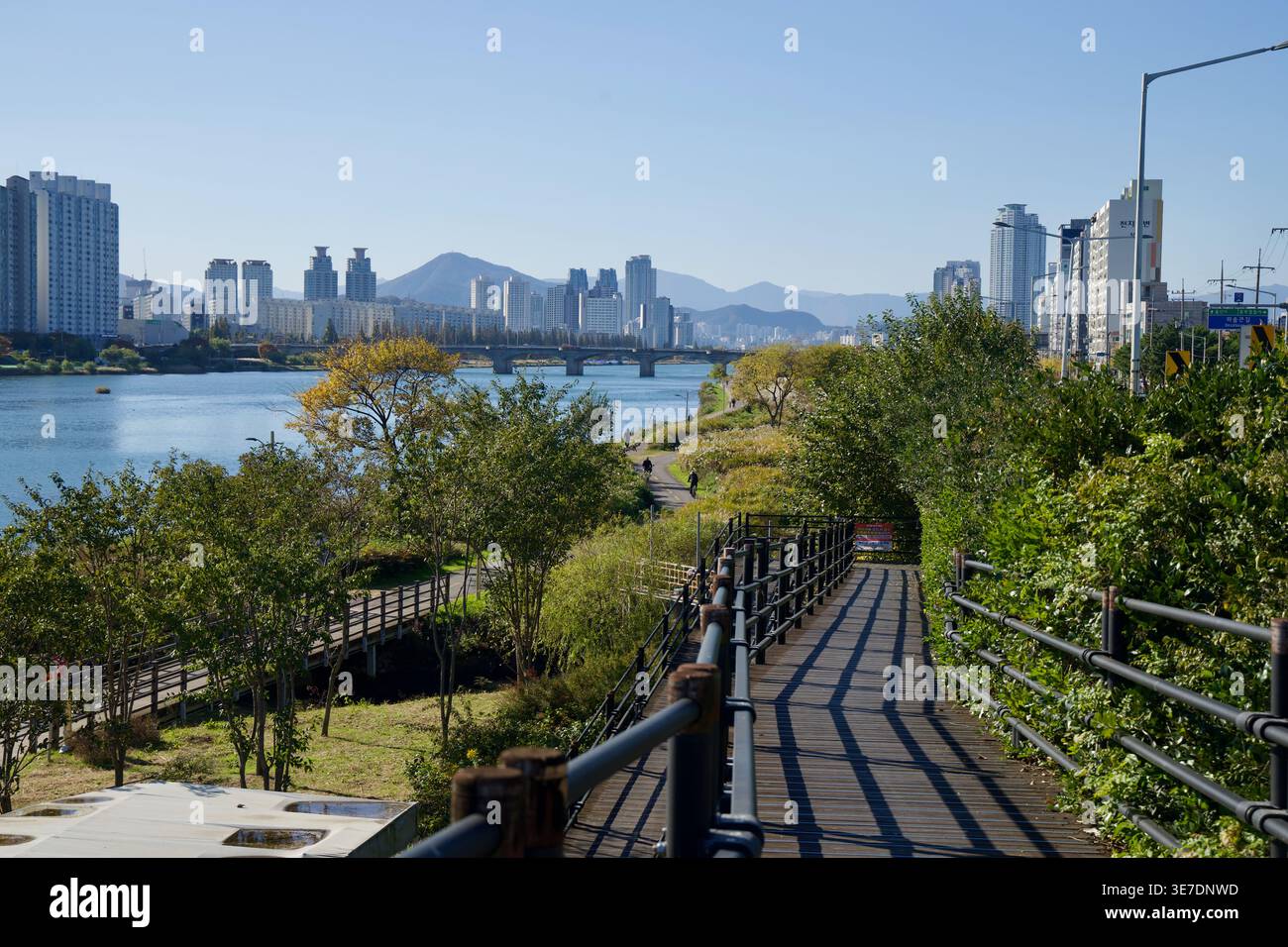 An elevated boardwalk overlooks the Taehwa River in Ulsan, with ...