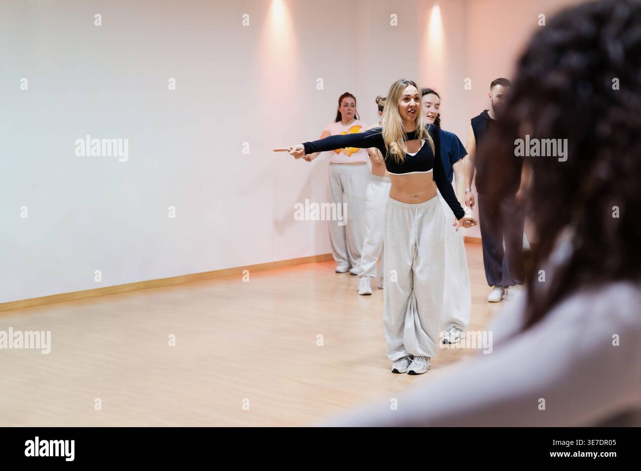 Female instructor leading dance class with students in studio Stock Photo
