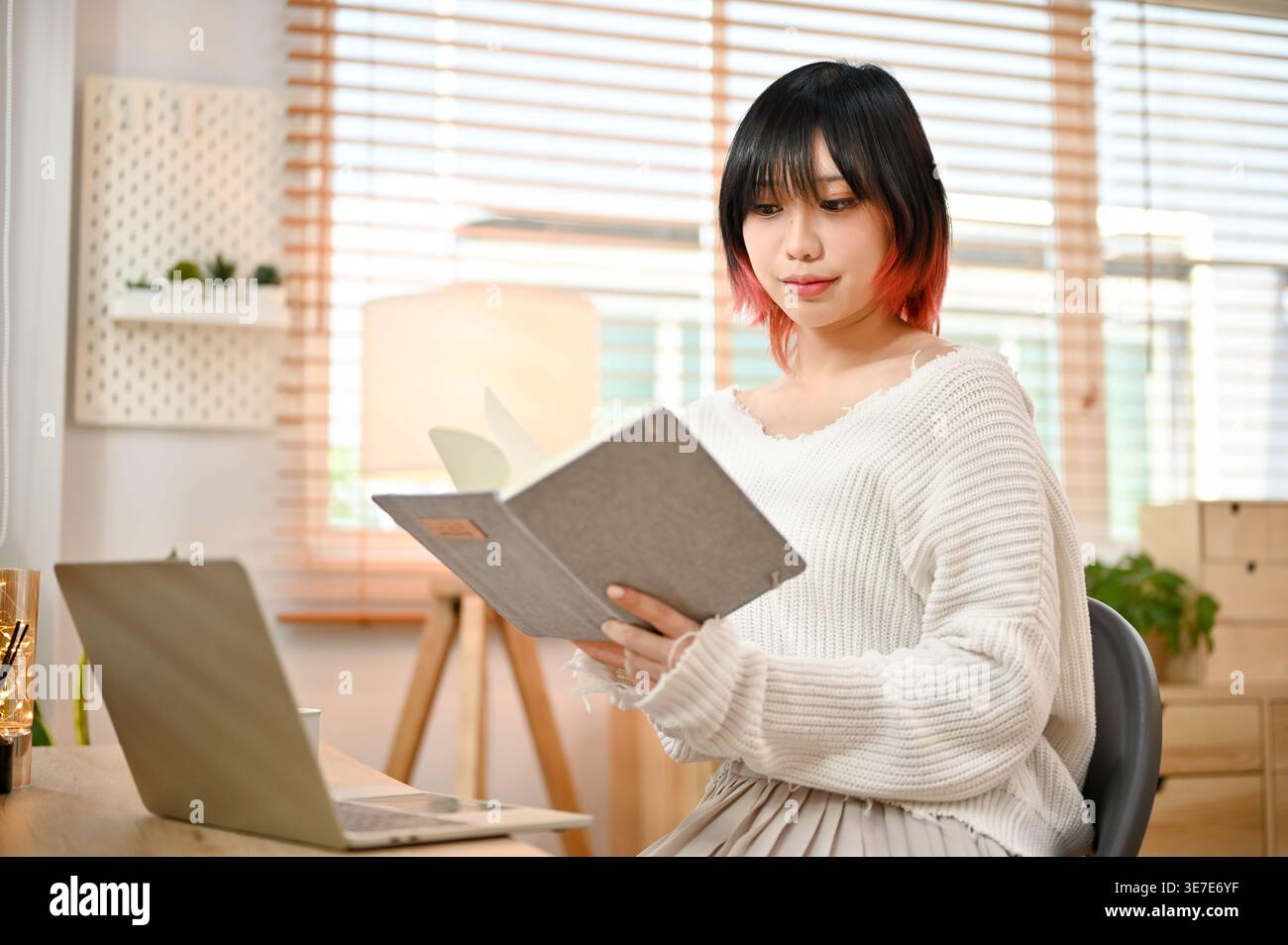 Beautiful Asian woman focusing on reading a book Stock Photo