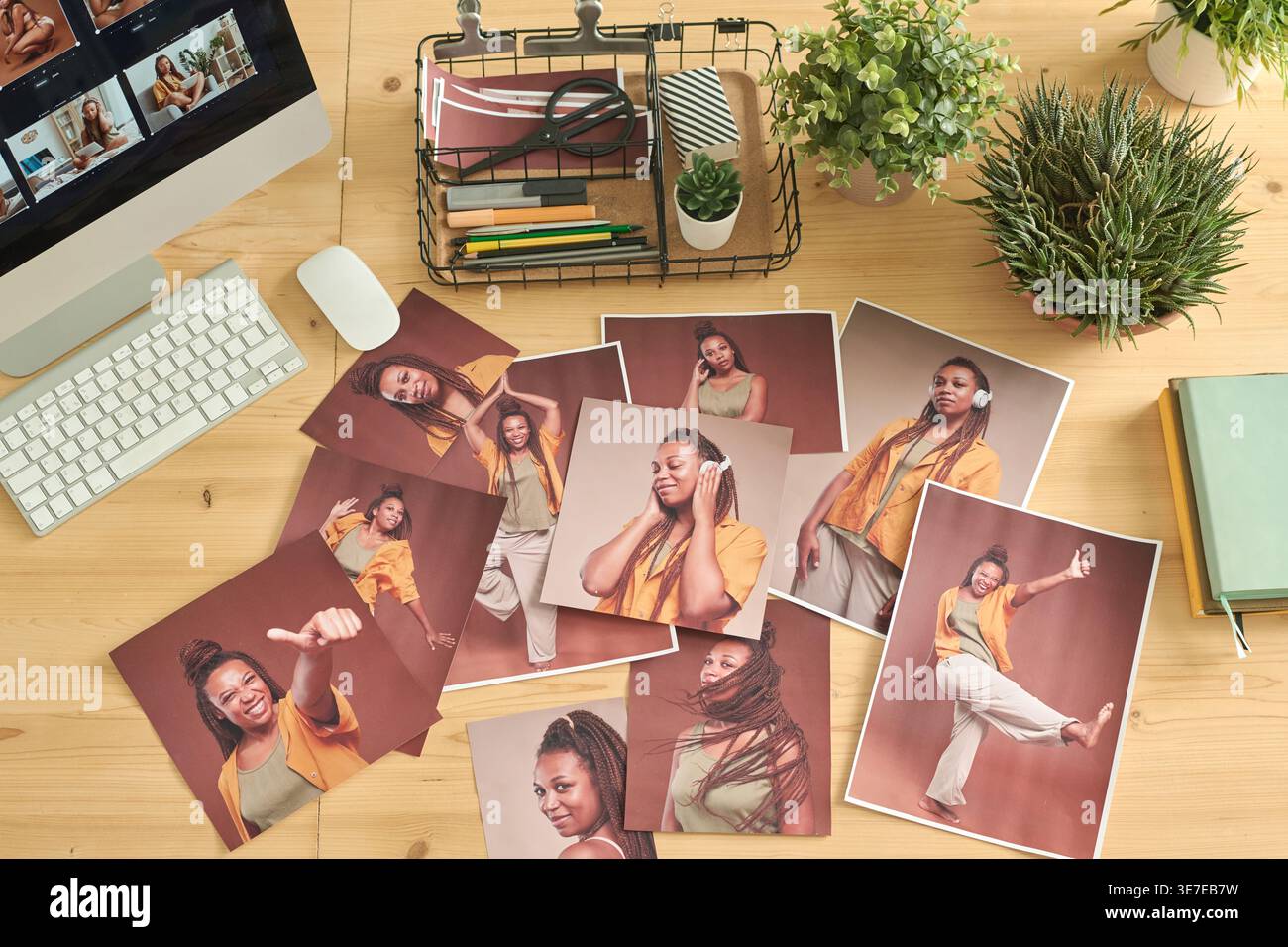 Photos of Black woman on wooden table with computer in office Stock Photo