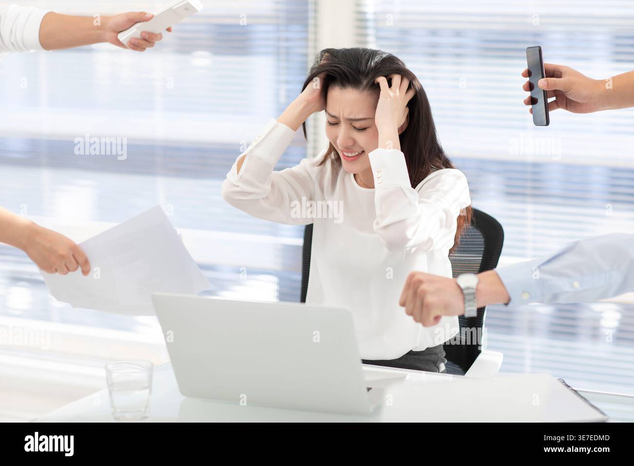 Frustrated business woman scratching head while sitting at table with computer in office Stock Photo