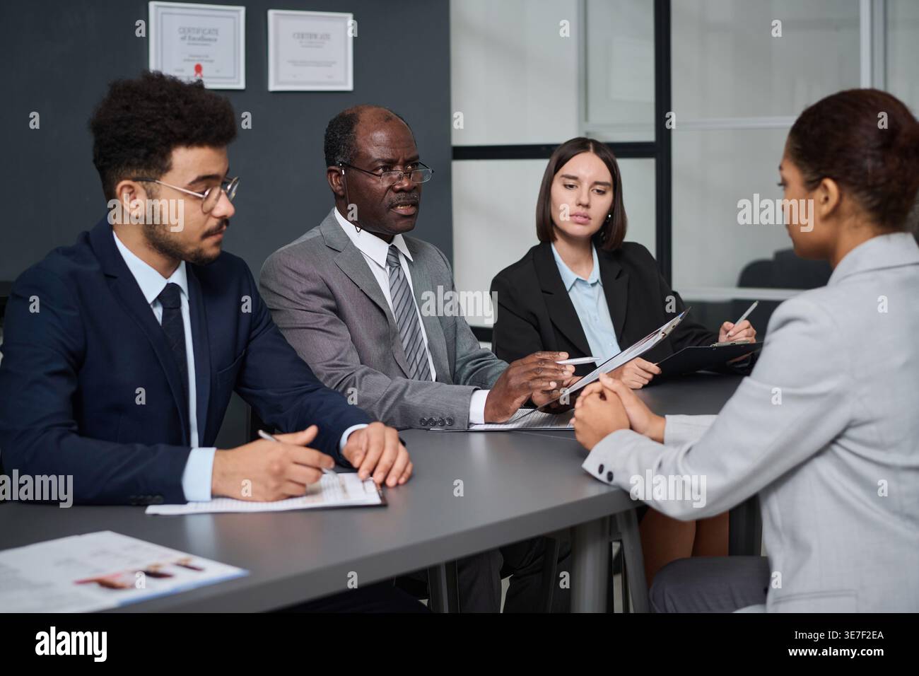 Group of consular officers holding pens and documents having interview ...