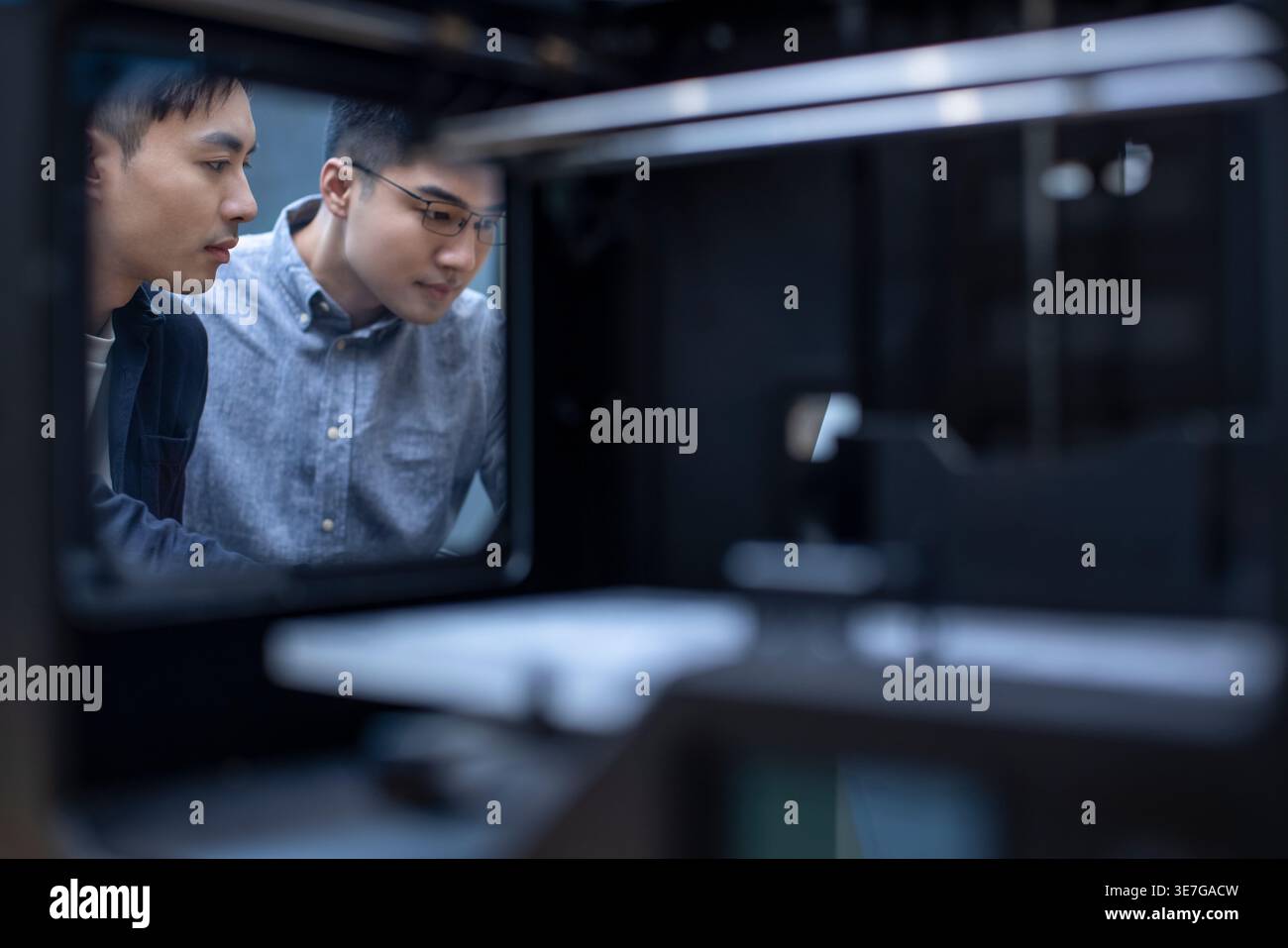 Chinese male IT experts using 3D printer in office Stock Photo