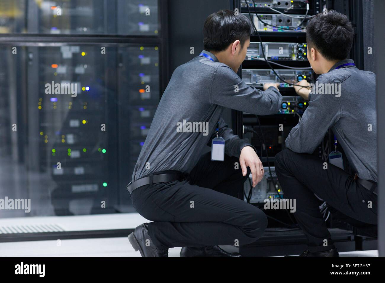 Chinese male technicians doing maintenance in computer room Stock Photo