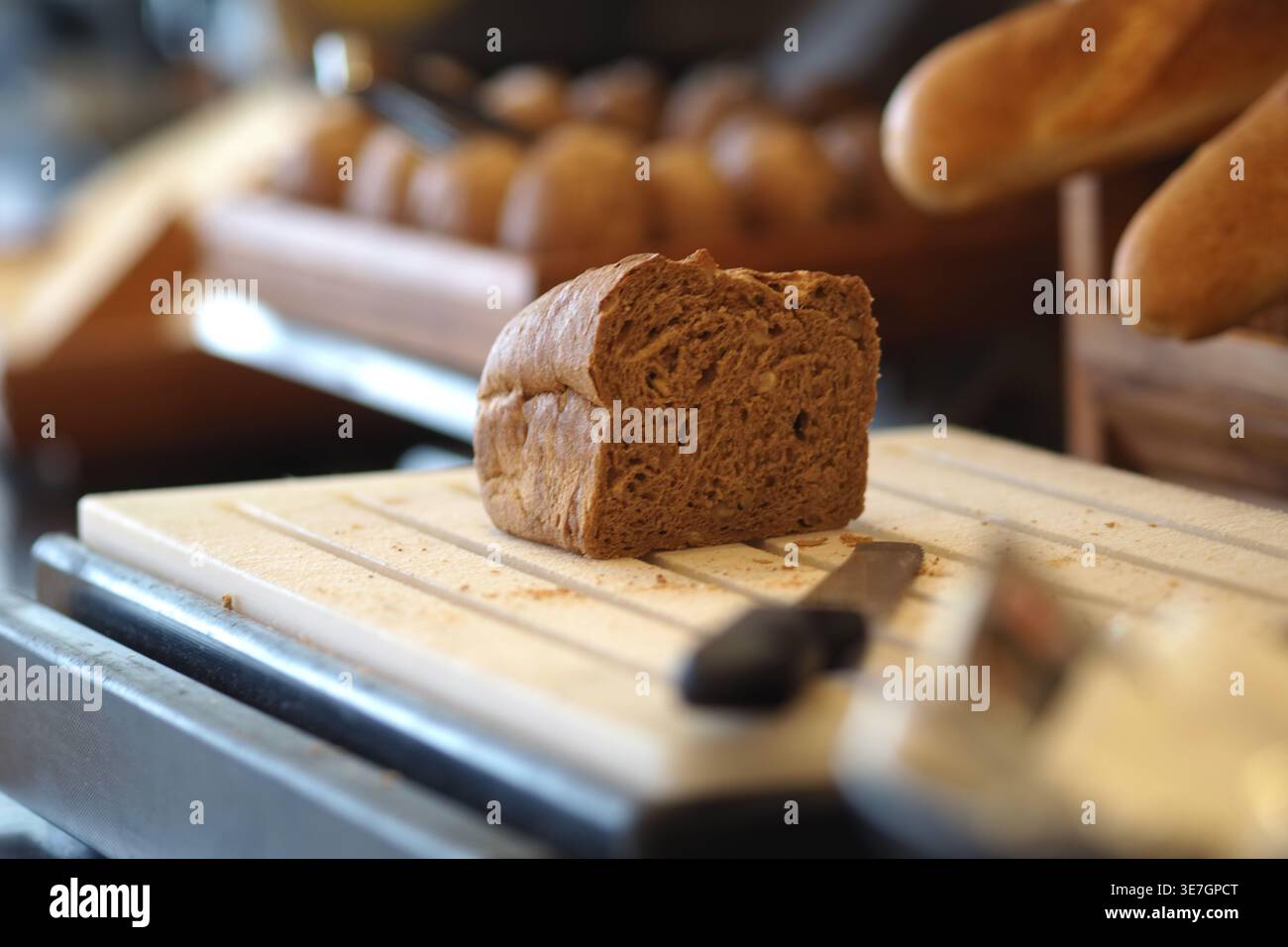 Freshly baked bread sitting on a cutting board Stock Photo