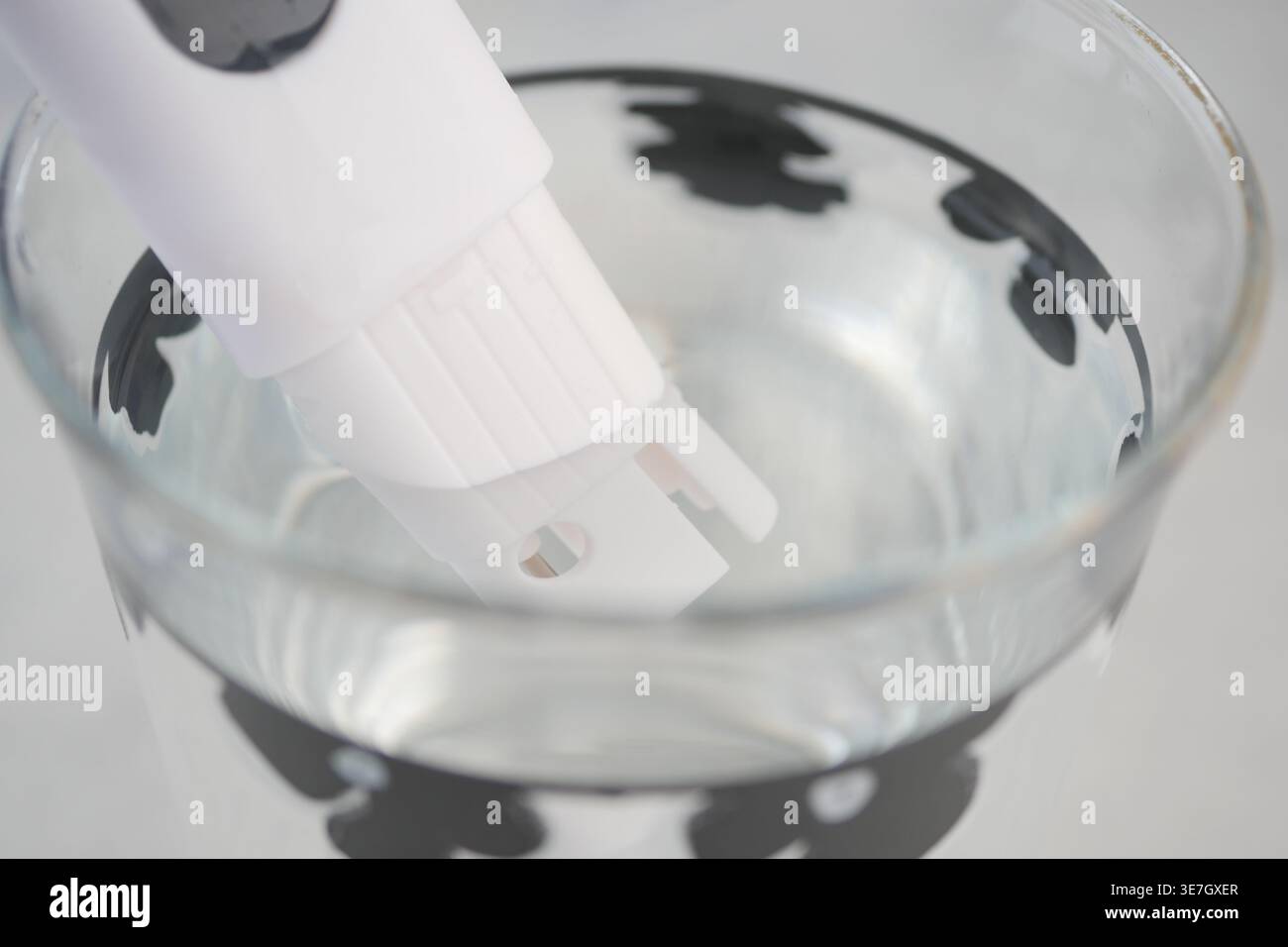 Handheld Water Quality Tester Probe in Glass Of Clear Water For Home And Laboratory Testing Stock Photo