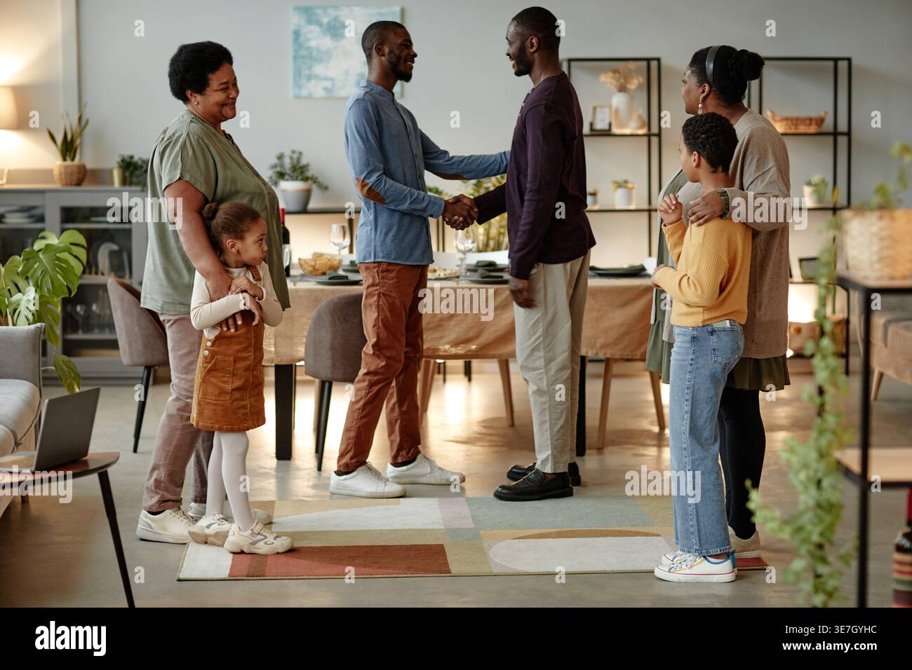 black-family-greeting-each-other-while-welcoming-guests-for-dinner