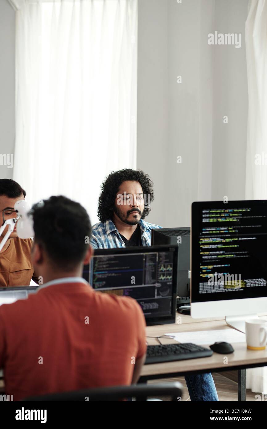 Indian male web developers writing codes for new computer program in IT office Stock Photo