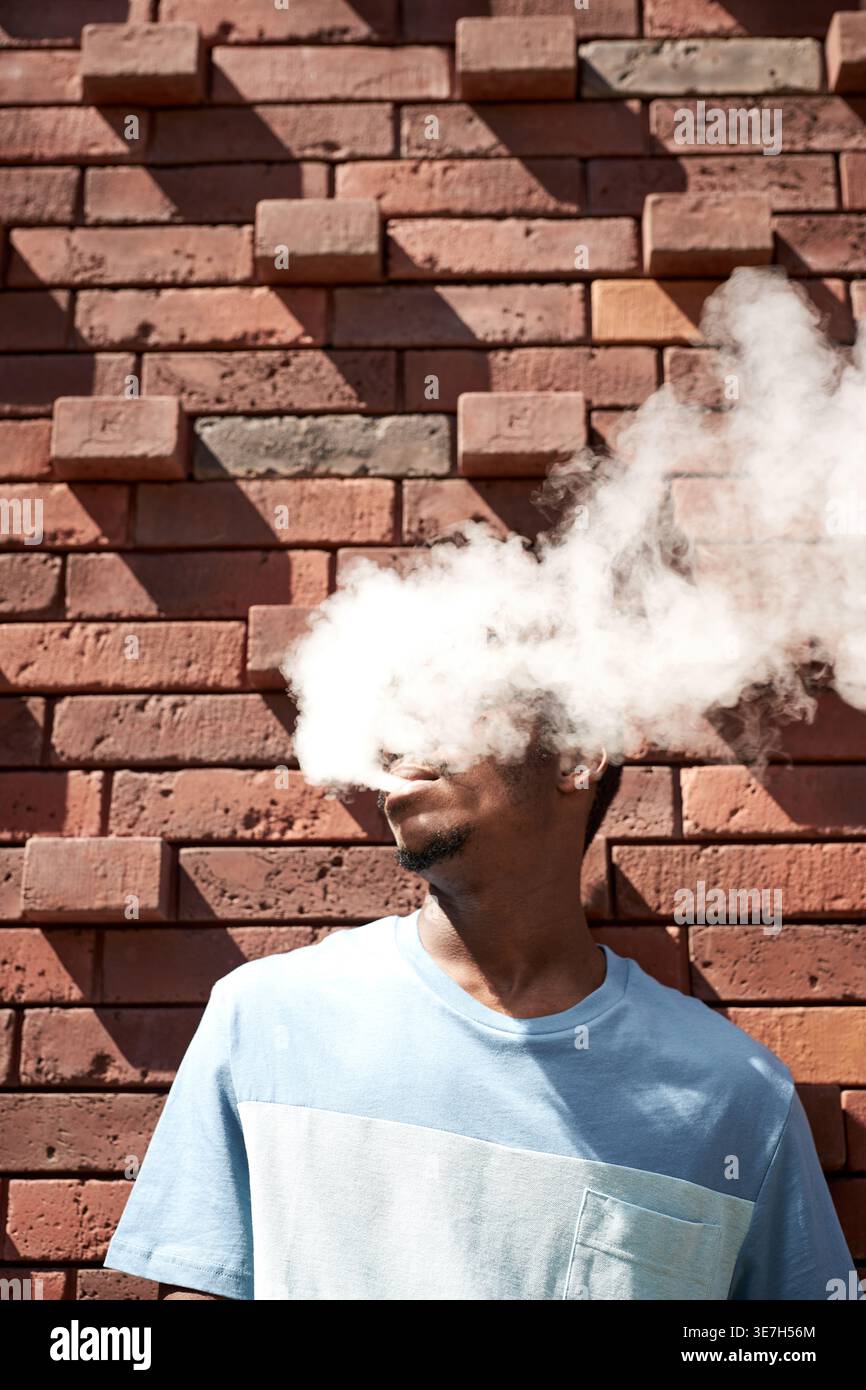 Man smoking cigarette on wall hi-res stock photography and images