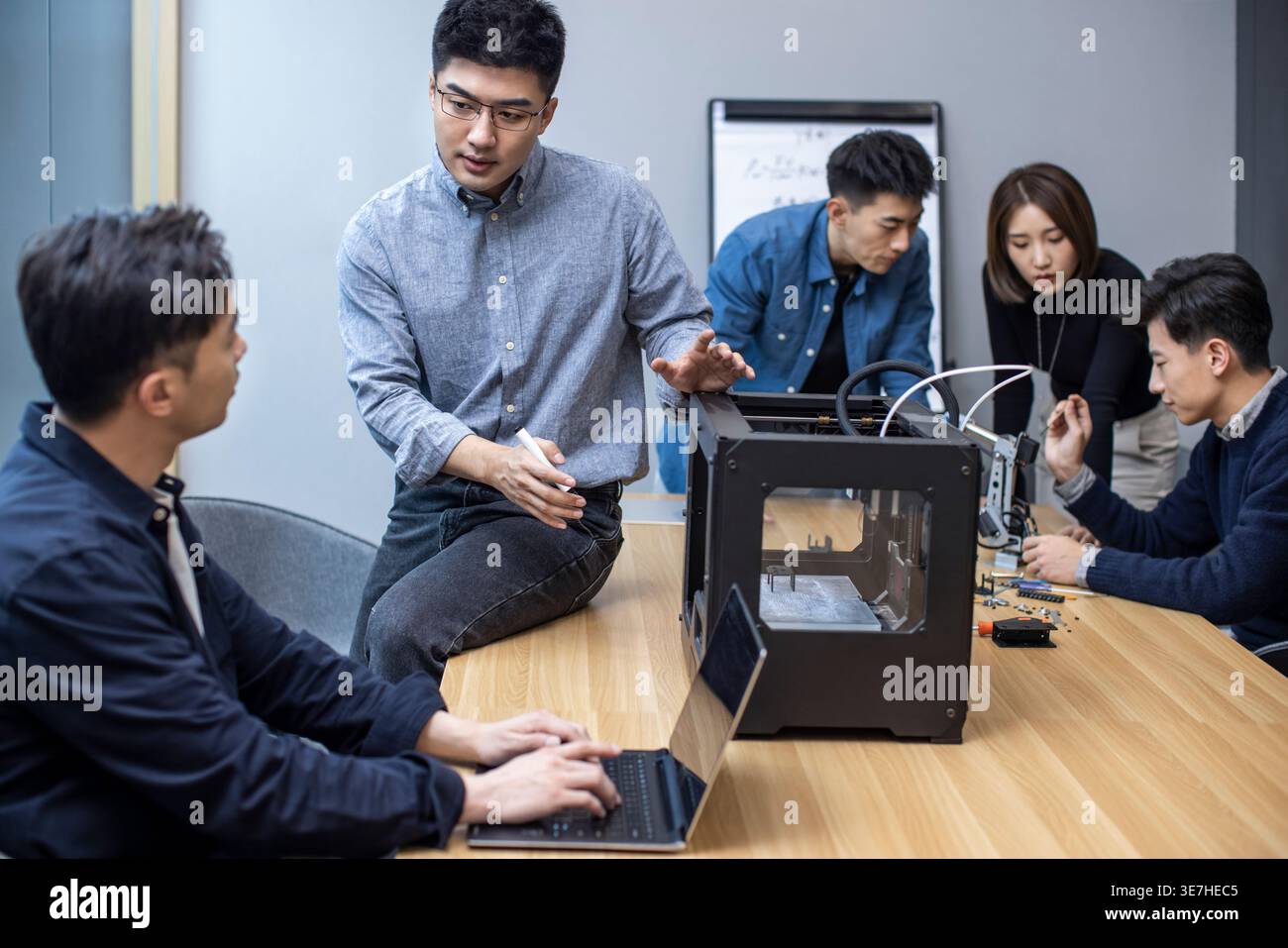 Chinese IT experts using 3D printer in making robotic arm in office Stock Photo
