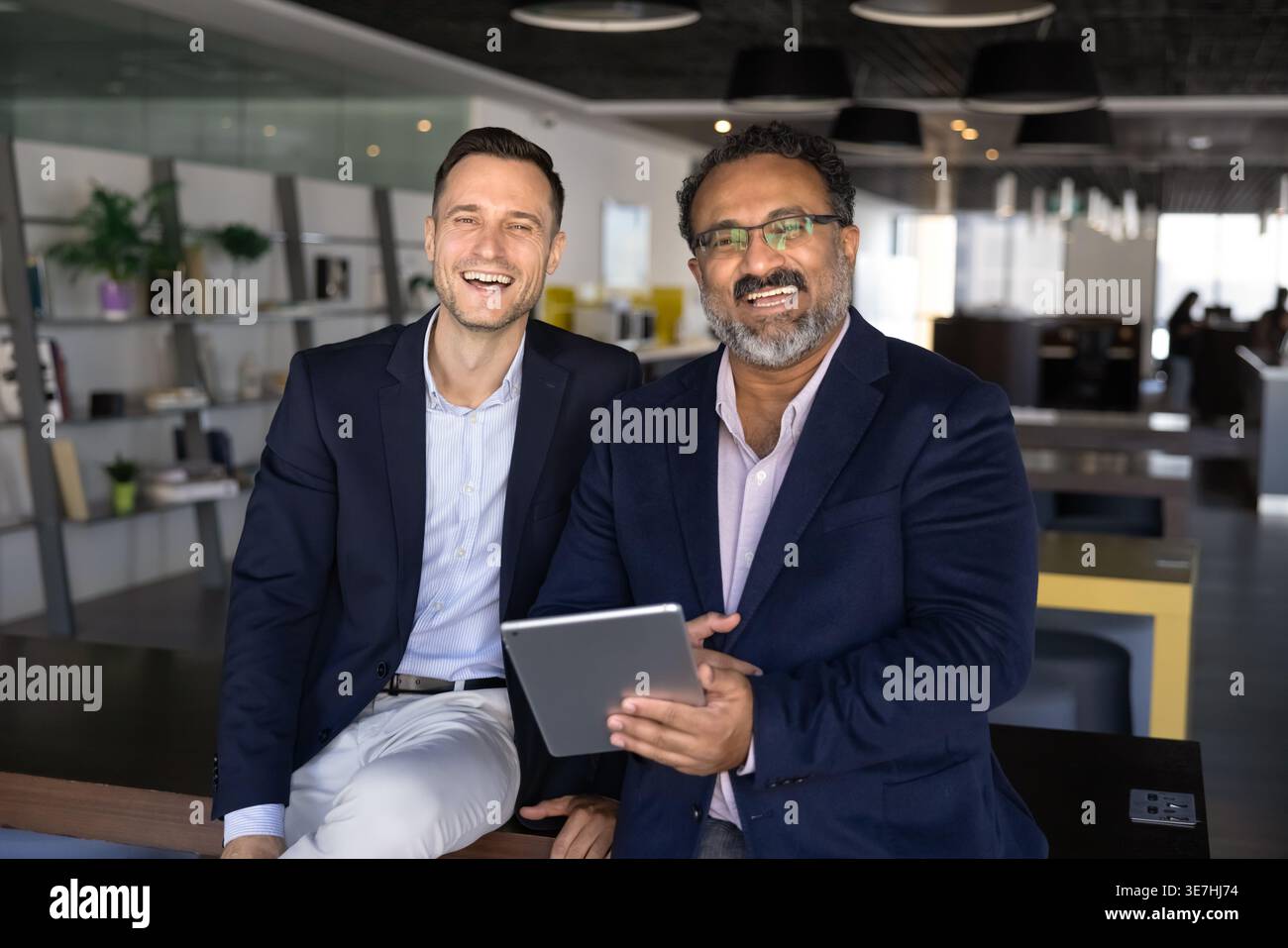 Happy staff members with digital tablet posing for camera Stock Photo