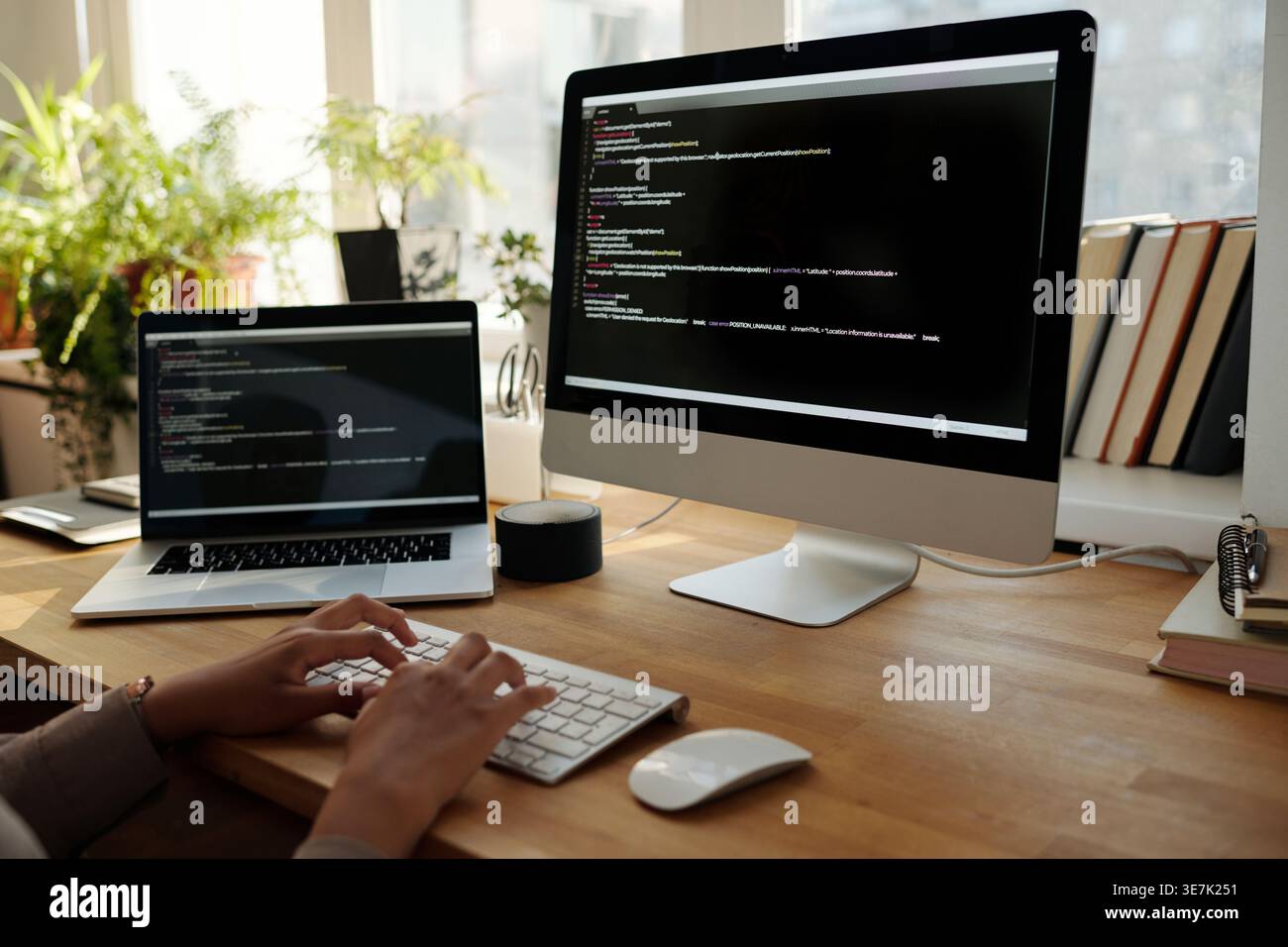Black female programmer in hijab working codes on computer while sitting at table at home office Stock Photo