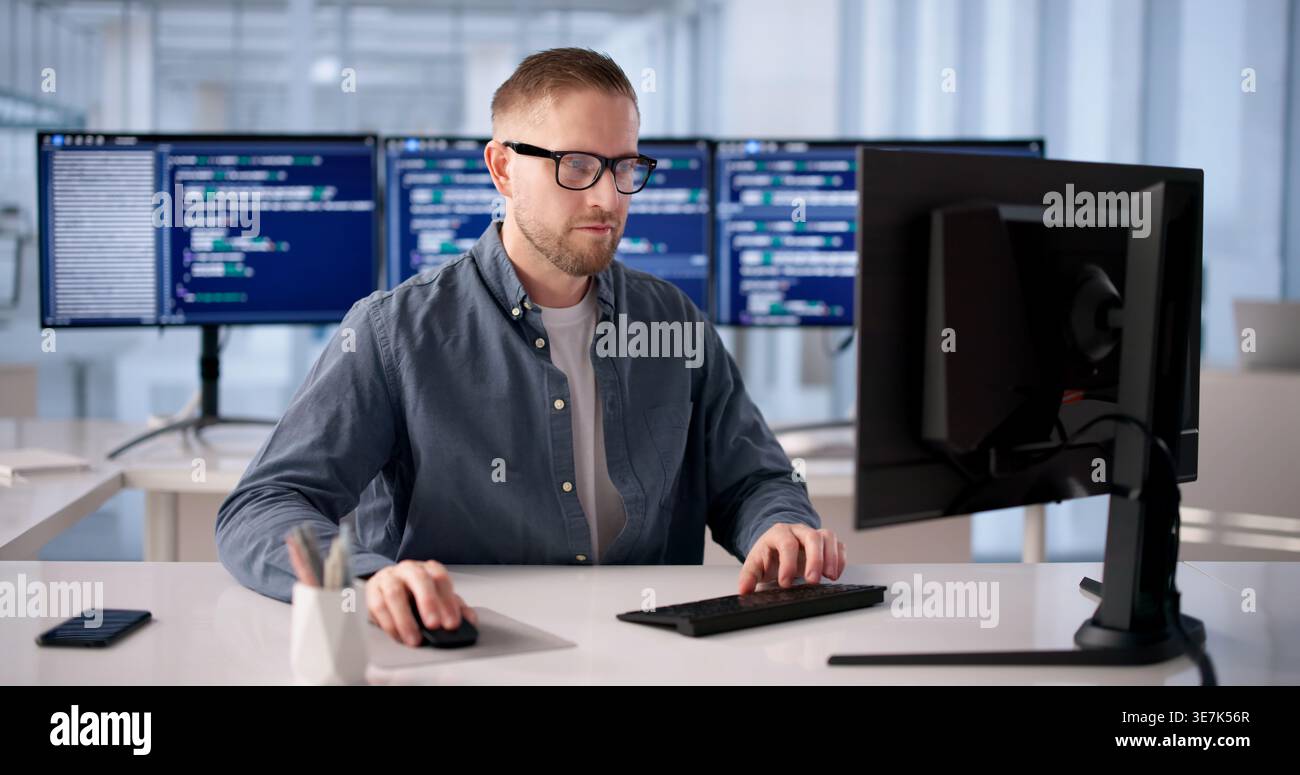 Focused Software Developer Programming At Office Desk Stock Photo