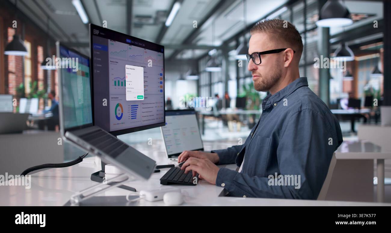 Young Professional Managing Cloud-Based Enterprise Software System On Laptop Stock Photo