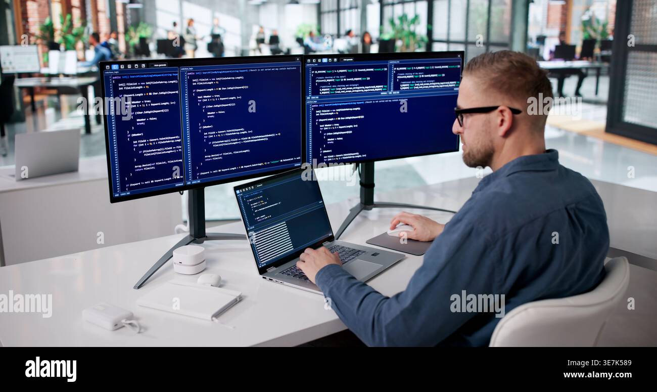Focused Programmer Developing Innovative Software At His Workspace Stock Photo